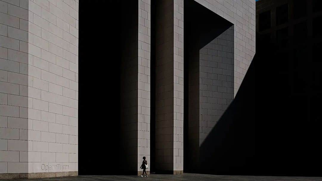 のインスタグラム：「Komparasi Besar - Kecil  Fotografer @arturobinewski berkeliling Frankfurt untuk mengambil foto bertema "tiny person and giant building". Tema foto ini adalah memberikan komparasi antara sosok manusia yang kecil di antara bangunan yang gigantis.  Untuk mengambil foto-foto ini, @arturobinewski menggunakan kamera  Fujifilm X-T4 dan lensa Fujinon XF18-55mmF2.8-4 R LM OIS. Pasangan kamera dan lensa ini memberikan ketajaman, kontras dan warna yang baik serta kemampuan mengambil ruang pada fragmen foto yang berdimensi.  Kamu bisa membuat tema foto seperti ini, temukan komparasi objek yang ukurannya kontras di sekitarmu untuk memulainya!   Captured by @arturobinewski Using Fujifilm X-T4 Fujinon Lens XF18-55mmF2.8-4 R LM OIS.  #XT4 #XT4_id #XF1855mmF284RLMOIS. #FujifilmIndonesia #Fujifilm_id」