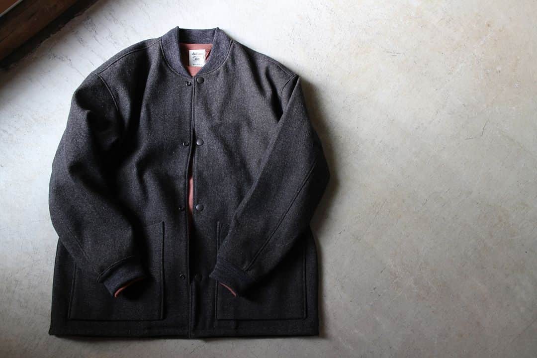 Jackmanさんのインスタグラム写真 - (JackmanInstagram)「▽ FW23 MELTON AWARD JACKET JM8380 70%WOOL 20%POLYESTER 5%NYLON 5%ACRYL Color:87Black Mix  経糸のみを2重にした 珍しい二重織りメルトン素材を使用した アウォードジャケットです  多色織りのためシャトル織機ではなく レピア織機を使用して 奥行きのある色合いを 生地で表現しました  ウール織り生地は本来 洗いと縮絨により 独特の膨らみがある表情に仕上げますが このアウォードジャケットは 1900年代初頭の クラシカルな表情にするため 縮絨をせず柔らかみのない 油分が抜けた風合いにしました  デザインは ゆったりしたシルエットに ボリューム感のある2枚袖 衿リブはコンパクトなシングルタイプの Baseball仕様です  中綿が入っていない分 裏地には防風性の高い 高密度タフタを使用  厚手のインナーも無理なく着用できる 工夫をしました  The Award Jacket features a rare double-woven melton fabric with only the warp having two layers. For multicolor weaving, a rapier loom was used instead of a shuttle loom to express the deep colors in the fabric. While typical wool fabric is finished by washing and fulling it to provide its unique texture and fullness, we omitted the fulling so that the jacket would lack softness and be oil-free to achieve a classic look reminiscent of the early 1900s. The design features a relaxed silhouette, voluminous double sleeves, and a compact single-rib collar like they use in baseball. While there is no padding, we used high-density taffeta lining for the backing to provide wind protection. We also made accommodations to allow for the thick inner layers to be worn comfortably.」11月7日 19時00分 - jackman_official