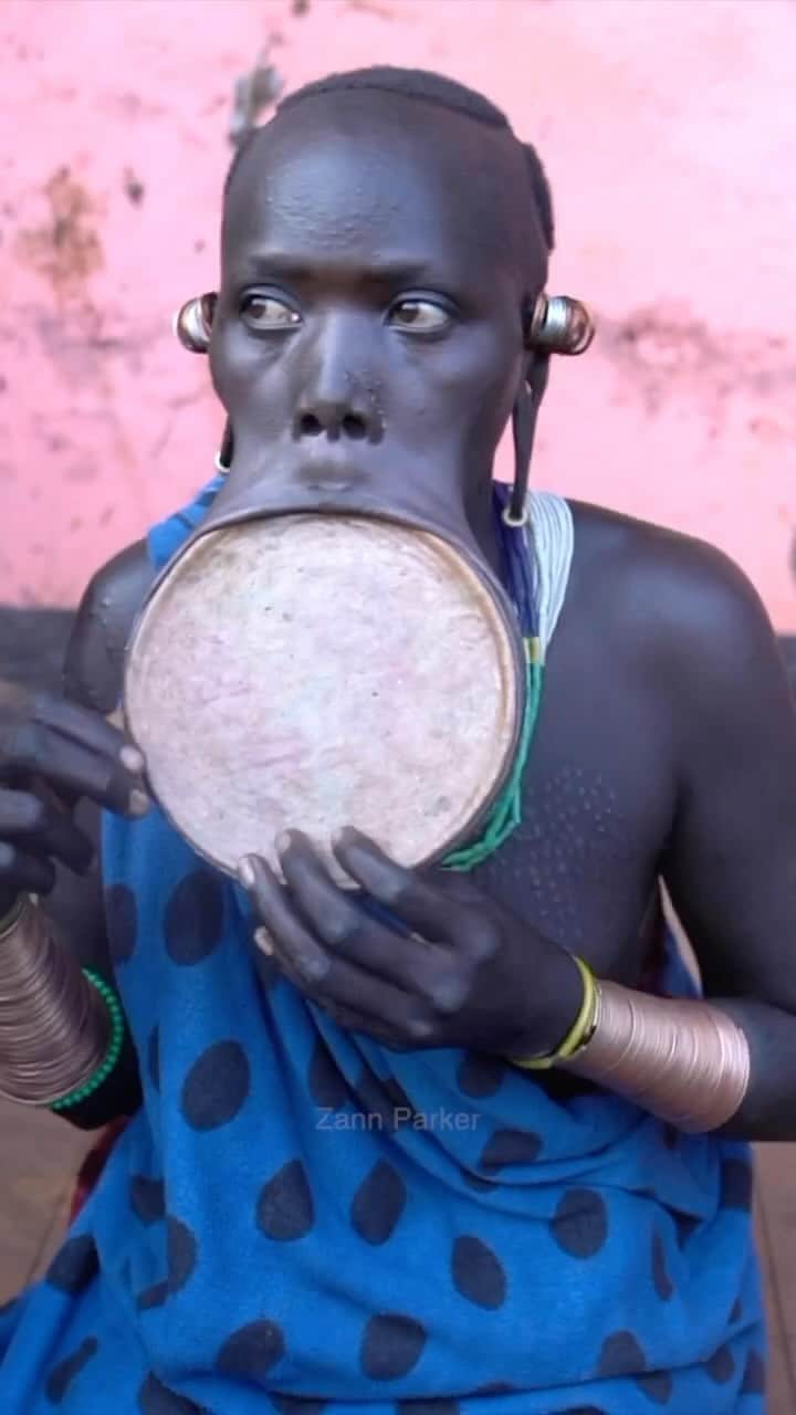 Earth Picsのインスタグラム：「@zannparker - The Surma Tribe, based in Ethiopia 🇪🇹, is renowned for their practice of wearing lip plates. This cultural tradition involves young women stretching their lower lips to accommodate large circular plates. The reasons behind this practice include its significance as a symbol of cultural identity and tribal affiliation, marking a rite of passage into womanhood, and potentially influencing marriage prospects and social status.   In their culture, the larger the lip plate, the more beautiful they are considered.  🎥 by @zannparker  📍 Ethiopia 🇪🇹 Surma Tribe」