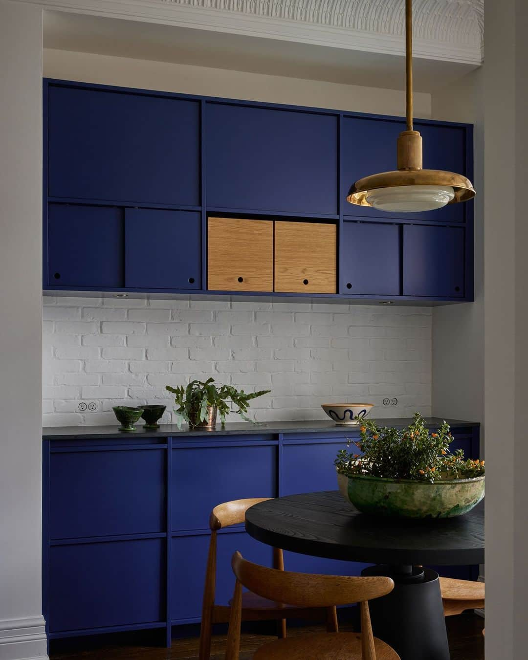 ELLE DECORのインスタグラム：「Looking for an alternative to all-white kitchen cabinets? Try blue! In this Toronto Victorian designed by Sam Sacks (@samsacksdesign), the shade (@benjaminmoore’s Blue) elevates the cupboards to sculptural monoliths, rather than mere storage. A white brick backsplash, meanwhile, gives the space a bit of loft-like cool.   To see inside this lively and immensely livable residence, as shown exclusively on elledecor.com, click the link in bio. Written by @cokhio. Photographed by @lomillerphoto.」