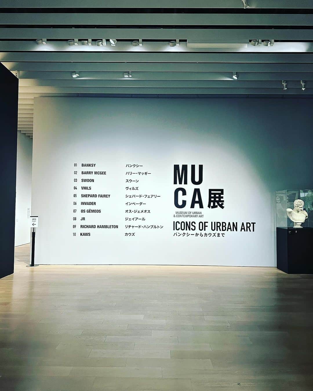 落合健太郎のインスタグラム：「京都市京セラ美術館　新館東山キューブ  「作品を観ているのではなく、作品に見られている」 そんな気持ちになった。  Museum of Urban and Contemporary Art（MUCA） は2016年にクリスチャンとステファニー・ウッツによってドイツ初のアーバン・アートと現代アートに特化した美術館として開館。 都市の景観を作品の一部として主に収蔵している。 自分達の生活と身近な事がテーマとなった 作品も多く、現代が抱える社会的問題や 作者が作品に込めた想いがストレートに 伝わってくる。 美術品を鑑賞するというより 事件を目撃しているような 大きなインパクトを覚えた。 MUCA展、2024年1月8日まで開催中。 #muca  ##muca展  #京都  #京セラ美術館  #banksy  #kaws  #invader」