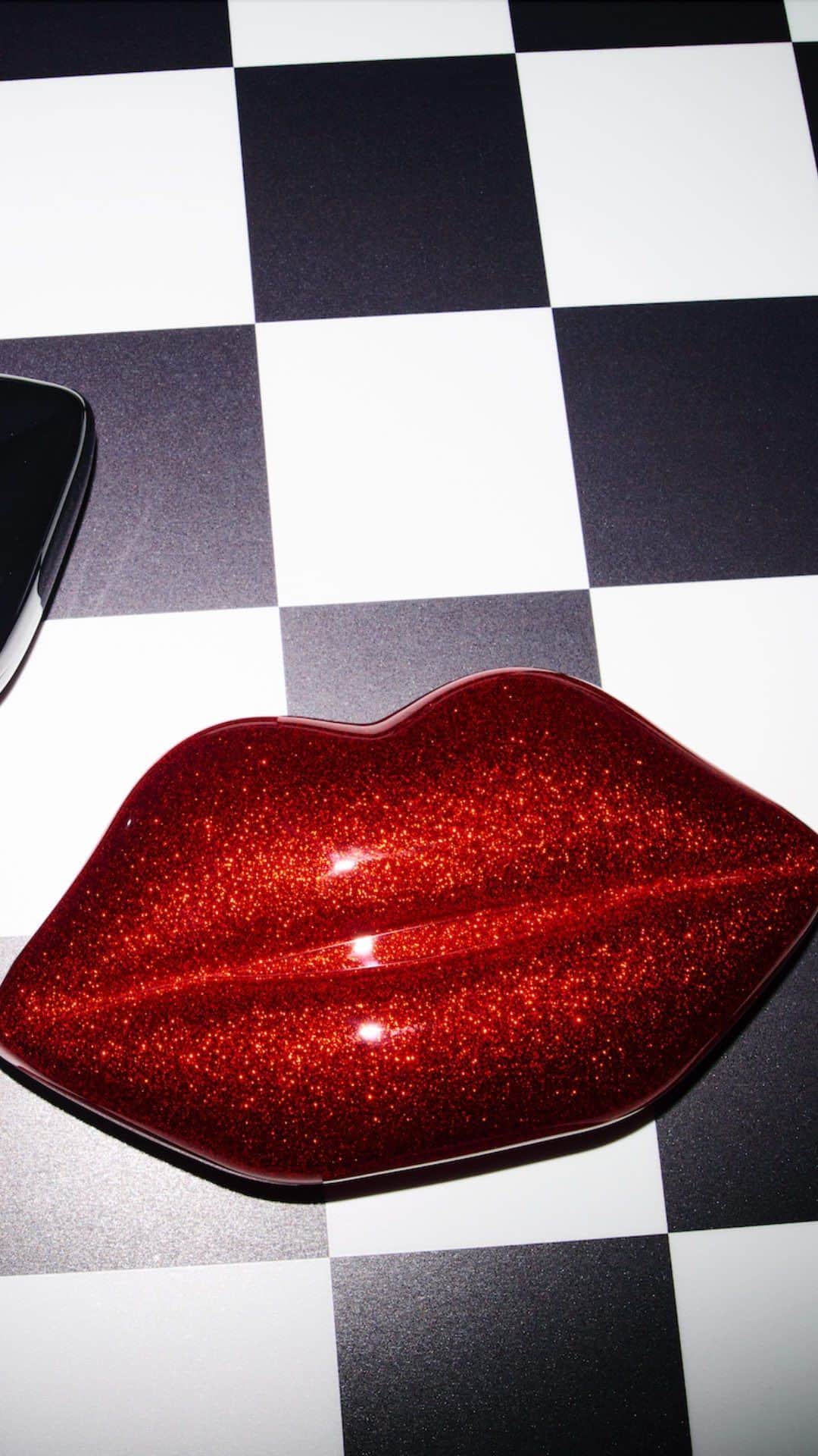 ルルギネスのインスタグラム：「Welcome the new edition to your collection💋 Own a glamorous icon with the acrylic Lips Clutch with a fine glitter Lulu Red finish. This statement party piece comes with a detachable gold chain strap to carry crossbody.  Available online now.  #LuluGuinness」