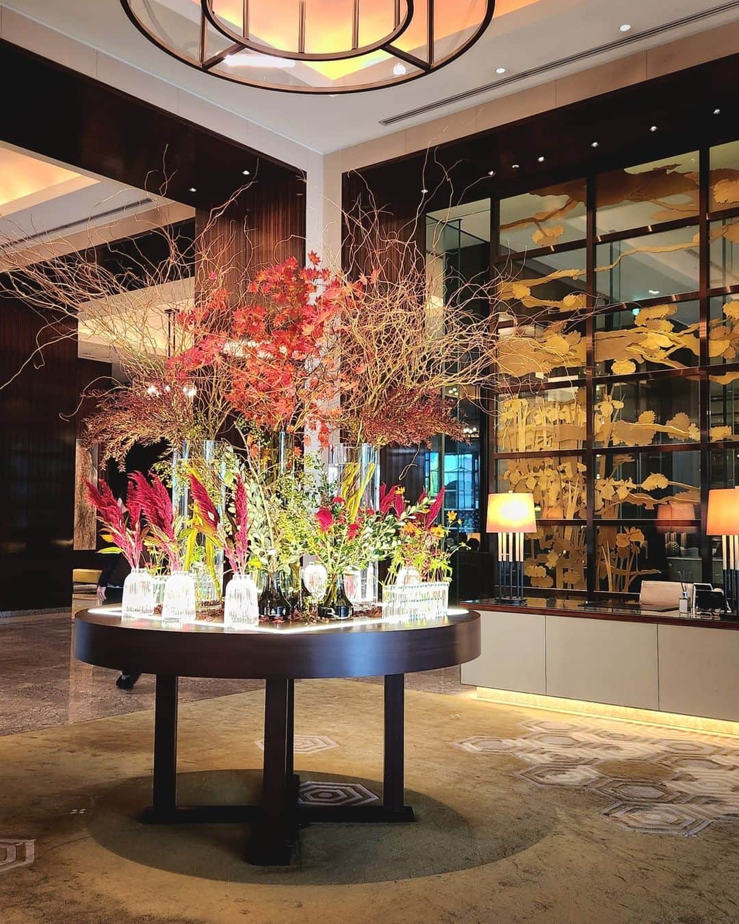 Palace Hotel Tokyo / パレスホテル東京のインスタグラム：「【#今週のロビー装花】 鮮やかな濃紅が深まる秋を彷彿とさせるロビーの装花。今週はこちらのお花でアレンジしています。 Step into our lobby and be captivated by our floral arrangement filled with autumn's crimson hues. The flowers used this week are...  ・ドラゴン柳 / corkscrew willow ・紅葉 / maple ・雪柳 / snow willow ・ツルウメモドキ / Japanese bittersweet ・久留米ケイトウ / Kurume cockscomb ・羽毛ケイトウ / feather cockscomb ・コスモス / cosmos ・ローズヒップ / rose hip ・フェイジョア / feijoa  @72.seven_two #PalaceHotelTokyo #パレスホテル東京」