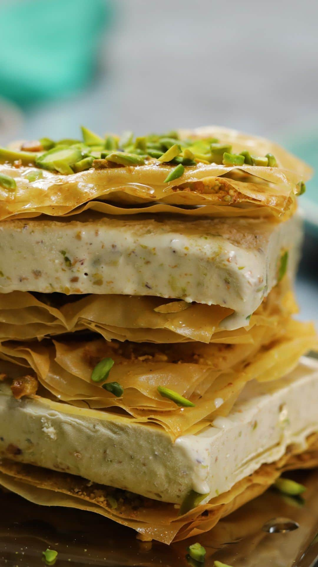 テイストメイドのインスタグラム：「【話題スイーツが進化！？】バクラヴァアイスサンド💚Baklava Ice Cream Sandwiches🍨✨  SNSで話題のトルコスイーツ「バクラヴァ」 熱々のシロップをかけて出来立てを食べるのが主流だけど 今回はアイスを挟んでアレンジ🍨  ピスタチオの濃厚さがたまらない…🤤  🎥: @tastemadeUK  ■材料 ピスタチオアイスクリーム 400g  ピスタチオ 150g ヘーゼルナッツ 50g シナモン 小さじ1 砂糖 大さじ2  溶かしバター 150g フィロペストリー 7枚  <シロップ> ローズウォーター 大さじ1 オレンジ 1個 蜂蜜 大さじ1  ■作り方 【事前準備】 ・少し溶かしたピスタチオアイスクリームを正方形のバットに広げ、3時間~一晩冷凍庫に置く ・フィロ生地は、湿らせた布巾で覆う等で乾燥しないようにする ・<シロップ>は混ぜておく  1.ピスタチオ・ヘーゼルナッツ・砂糖をフードプロセッサーに入れ、細かく撹拌する 2.10cm角に切ったフィローシートをバットに広げ、溶かしバターを塗り、1.をかけて指で広げる 3.さらにフィロシートを重ね、溶かしバターを塗る。これを4層になるまで繰り返す。 4.最後大きめに砕いたピスタチオを上からかけ、180度のオーブンで15分間きつね色になるまで焼き上げる 5.生地と同じ大きさにカットしたアイスを、焼けた生地で挟むように重ねる 6.シロップと余ったピスタチオを上からかけて、完成！  Ingredients: * 400g pistachio ice cream * 150g pistachios * 50g hazelnuts * 1 tsp cinnamon * 2 tbsp sugar * 150g melted butter * 7 sheets filo pastry * 1 tbsp rose water * 1 orange, zested * 1 heaped tbsp honey  #テイストメイド #料理 #cooking #dessert #recipe #icecream  #レシピ  #簡単レシピ #おうちご飯 #おうちごはん #パーティーメニュー #パーティーレシピ  #スイーツ  #おうちカフェ #おうちスイーツ #おやつ  #手作りスイーツ #バクラヴァ #バクラヴァレシピ #トルコ #トルココーヒー #トルコグルメ #トルコスイーツ #Turkishcoffee #トルコ料理 #トルコランプ #Turkish #Turkishfood #Baklava #クリスマス」