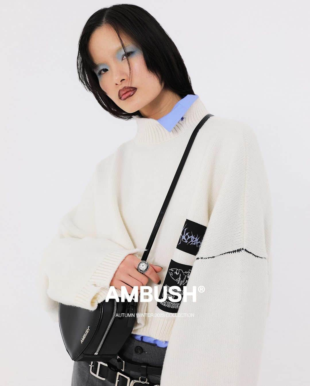 AMBUSHのインスタグラム：「#AMBUSH AW23  COLLECTION Layered-up collegiate style. Patched CROPPED KNIT SWEATER with distressed hems layered with the CROPPED OVER SHIRT and paired with the CLEAR CLASS SIGNET RING.   Now available at our WEBSHOP and WORKSHOP.」