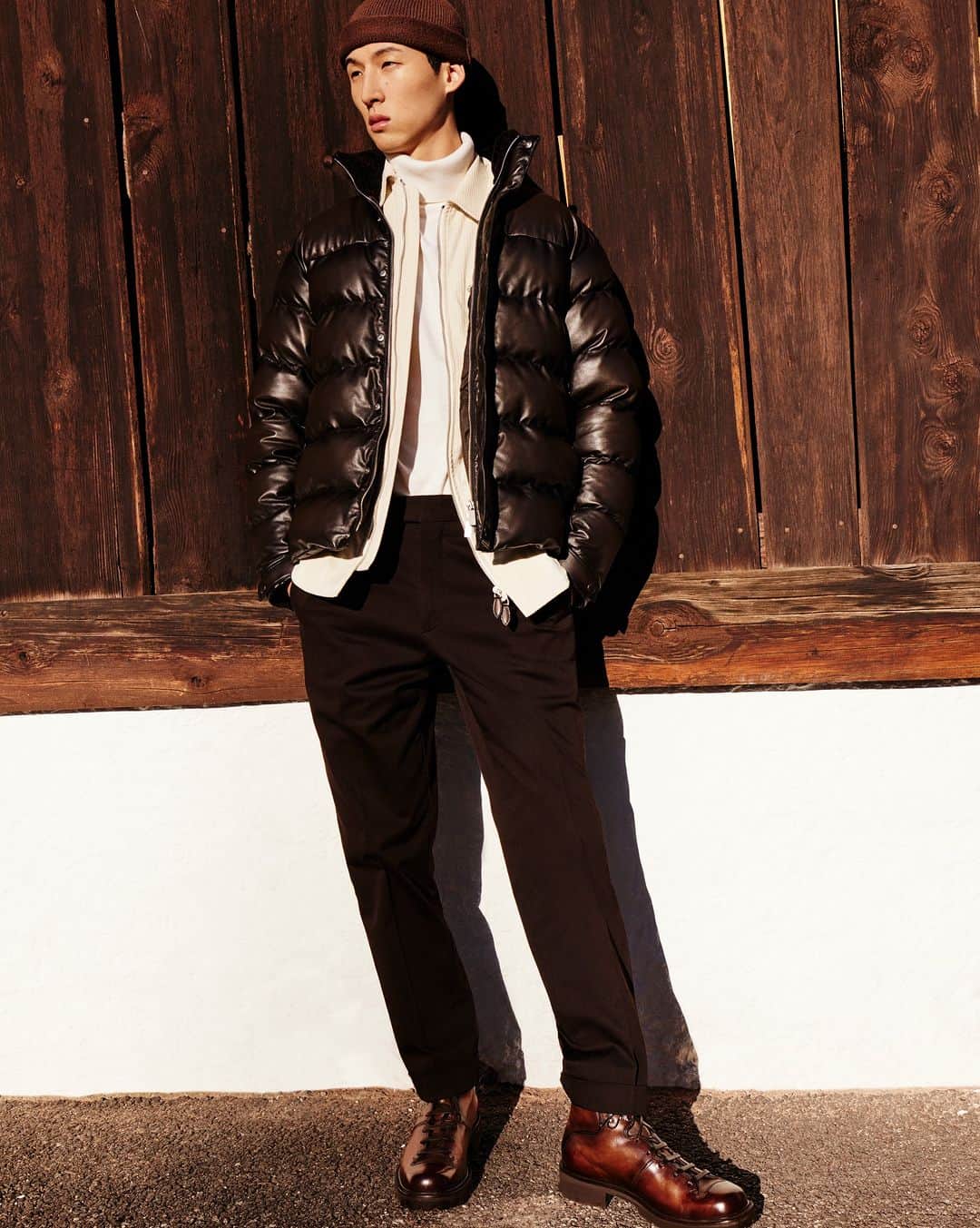 ベルルッティのインスタグラム：「- THE SILHOUETTE: PEAK POINT BY #BERLUTI -   There’s an adventurous sense of chic to this season’s Berluti wardrobe. As layering becomes a must to fend off the cold, a virgin wool turtleneck is worn under a cashmere overskirt and a lightweight patinated leather down jacket. Tapered joggers worn with Venezia Brunico boots add a casual twist. The finishing touch for a city-to-nature look? A cashmere beanie.   Now available online and in-store.  Styling by @virginiebenarroch  Photography by @anthonyseklaoui   #BERLUTIWINTER2023」