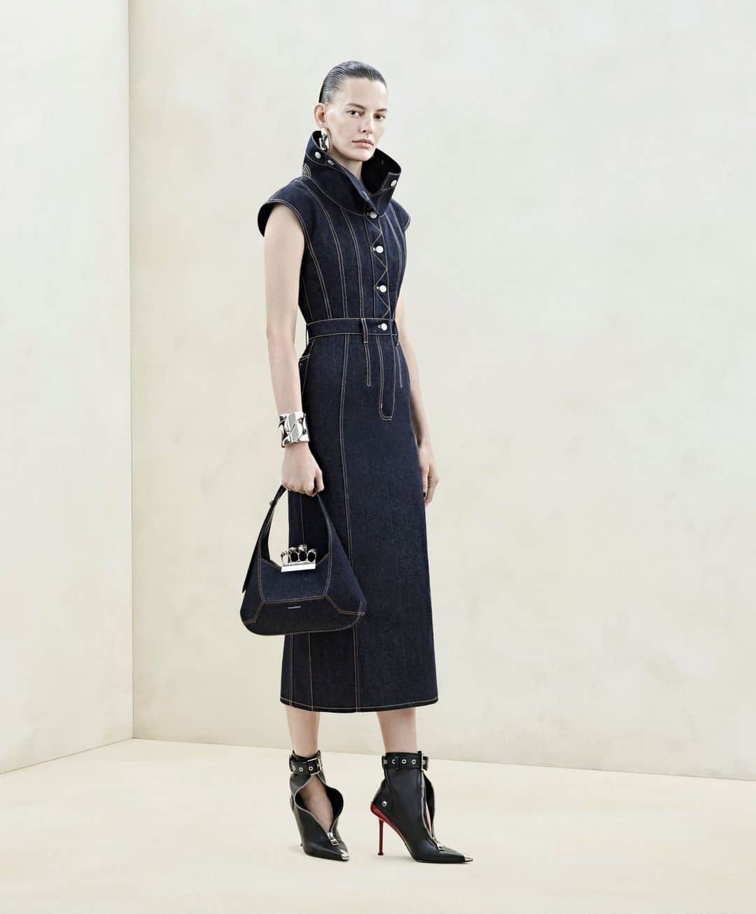 アレキサンダー・マックイーンのインスタグラム：「An indigo denim dress with contrast stitching and funnel neck detailing worn with the #McQueenHoboBag and Slash Biker boots. ⁣ ⁣ Discover the #McQueenAW23 collection via the link in bio.⁣ ⁣ Photographed by @Jet.Swan⁣ Video by @EbbaHult⁣ Track: Neurons by @roblewiscomposer⁣ Music Director: John Gosling」