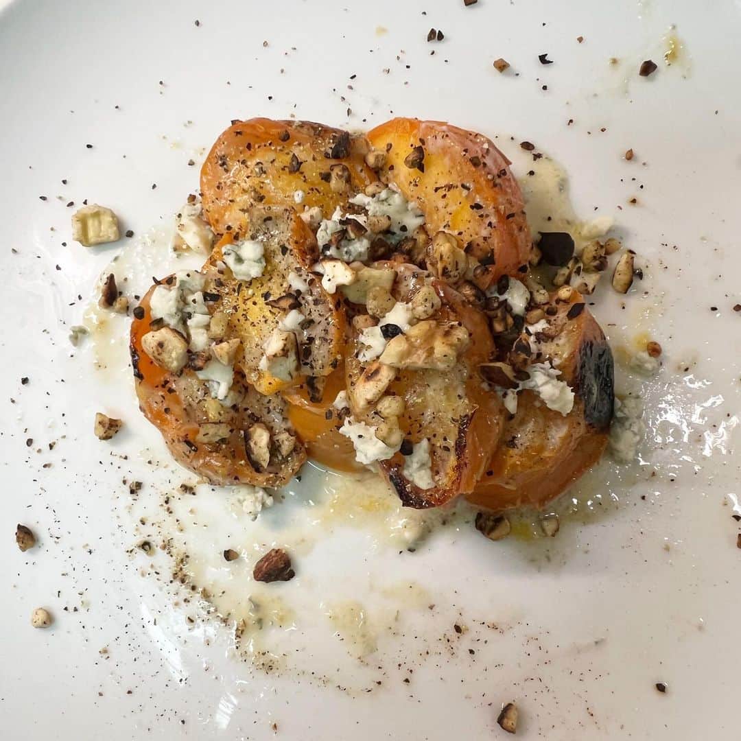 ハシモトタカヒロのインスタグラム：「焼き柿のブルーチーズ和えローストナッツ。 柿を焼くと甘くなると聞いて調べたらチーズと和えるとあまじょっぱになると、で胡椒もぱらり。ローストした胡桃を乗せると香ばしいときたらべらぼうに旨くできました。ワインにあうぅ〜バニラアイスのせても美味しいかも😇」