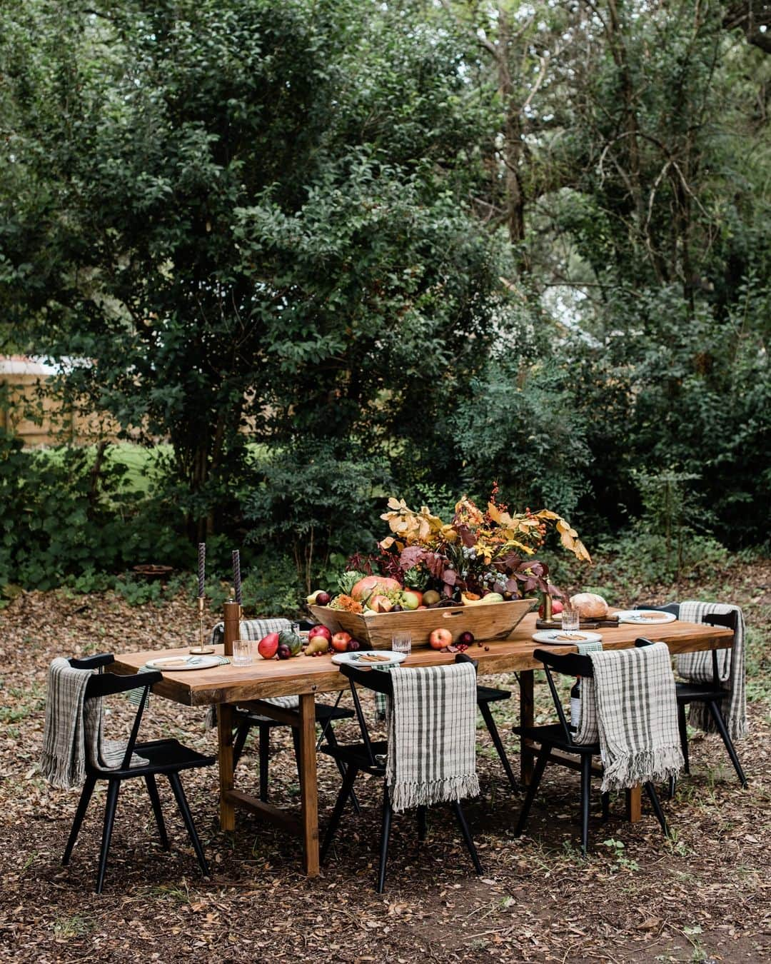 ELLE DECORのインスタグラム：「Happy Thanksgiving from all of us at ELLE DECOR! For all the last-minute hosts out there, we’re offering you one final tablescape idea to help you bring it all together. This alfresco look, courtesy designer Anastasia Casey (@theinteriorcollective), showcases the bounty of fall in all its glory. A generously sized wooden tray acts as a receptacle for pumpkins, fresh produce, gourds, and botanicals. It’s further complemented by a set of moody tapered candlesticks and individual seat blankets. Casey says she also likes to add things that can be interactive to the table as the guests are arriving. “I keep crusty, warm bread wrapped in plaid napkins on the table to engage conversation,” she adds. That’s it, we’re inviting ourselves to this one.  Hungry for more? Click the link in bio for more Thanksgiving table ideas. Written by @rachelesilva_. Photographed by @laceysombar.」