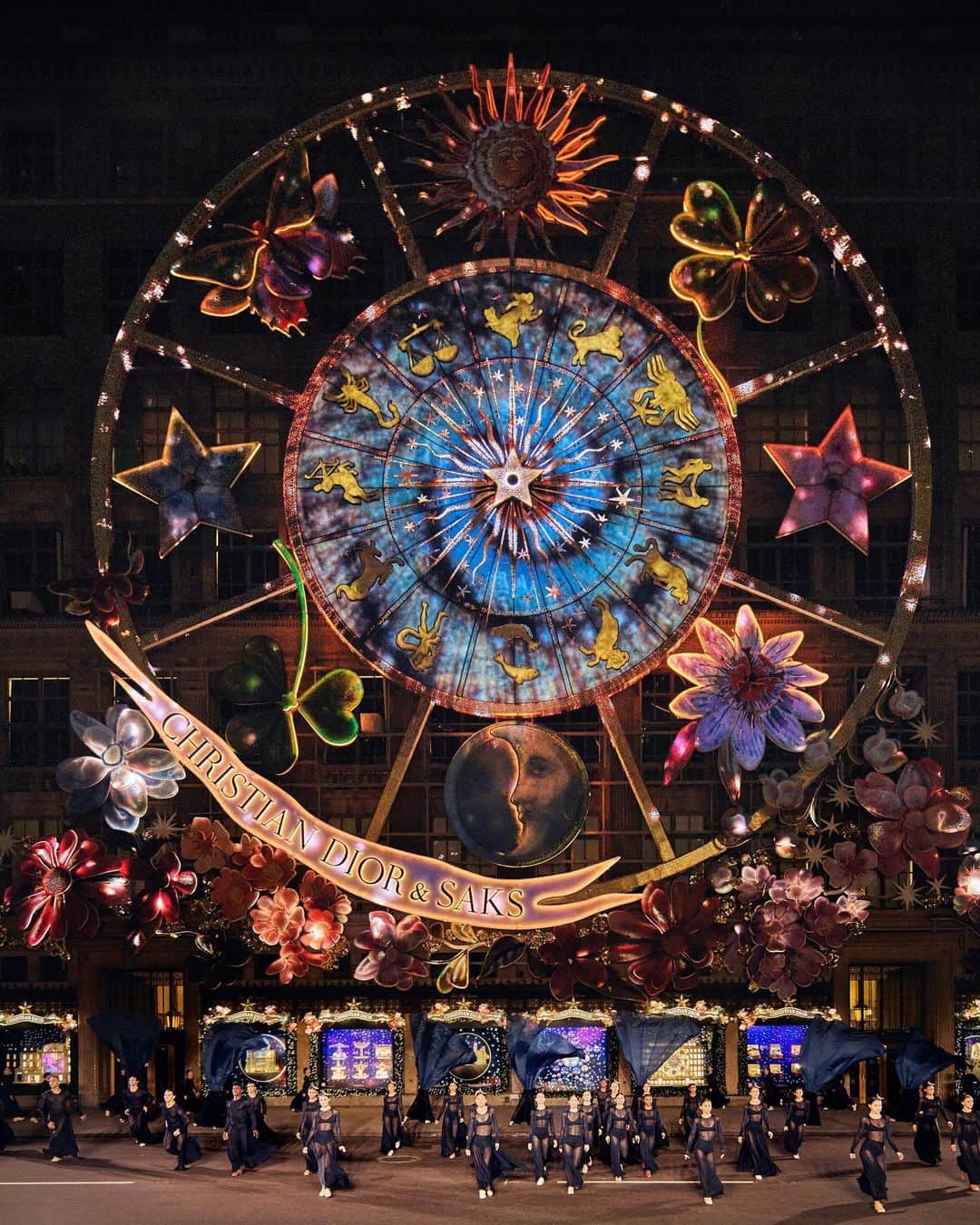 のインスタグラム：「The launch of Dior's Carousel of Dreams at @Saks was marked by a performance from the @MarthaGrahamDance company, infusing Fifth Avenue with a ballet of light. The dancers, clad in @MariaGraziaChiuri’s navy blue knit silhouettes, designed for comfort and fluid motion, glided like figures from a fairytale. Their looks were completed with @StephenJonesMillinery's moon-shaped headdresses in glistening silver resin, sprinkled with stars, reflecting Christian Dior's legendary theatrical flair. © Photos: @JoePerri and @HereAndNowAgency Choreography: @VirginieMecene and Janet Eilber with classic movements by Martha Graham」