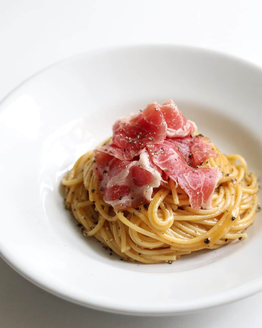のインスタグラム：「🍝 生ハムの焦がしバターカルボナーラ。 これは個人的にかなり好きなアレンジのおうちパスタ。 ⁡ 焦がしバターの風味と生ハムの旨みの組み合わせがたまらないので、ぜひおうちで試してみてくださいな🤤 ⁡ ——————————— ⁡ ▹レシピ本 初著書「おうちで本格！BINANPASTA流 映えうまパスタレシピ」(宝島社)が11/17に発売決定📙ハイライトの【🎁レシピ本】にリンクあります。 ⁡ ——————————— ⁡ ✱ 今日のパスタ 『生ハムの焦がしバターカルボナーラ』 ⁡ ⋈ 材料(1人前) パスタ　80g 生ハム　適量 バター　15g ☆全卵　1個 ☆卵黄　1個 ☆粉チーズ　15g ☆ブラックペッパー　適量 塩　適量 ⁡ ⋈ 作り方 1. ☆を混ぜ合わせておきます。→★ 2. 沸騰したお湯の中に塩を入れてパスタを茹で始めます。 3. フライパンにバターを入れてバターが褐色になるまで加熱したら火を消しておきます。 4. 茹で上がったパスタと茹で汁（お玉1/2杯程度）をフライパンに入れて素早く混ぜ合わせます。 5. 次に★を加えてとろみが付くまで火加減に気を付けながら混ぜ合わせます。 6. お皿に盛り付けたら、仕上げに生ハムとブラックペッパーをトッピングして完成です。 ⁡ ⋈ 詳しくはHPでご紹介 https://binanpasta.com/prosciuttobuttercarbonara/ *プロフィール(@binanpasta )からアクセスできます。←愛用アイテム一覧もあります。 ⁡ ✱「BINANPASTAのレシピを参考に作ったよ」という方は、ぜひ @binanpasta をタグ付けして写真を投稿してください。XやThreadsも大歓迎👏👏 ⁡ -——————————— ⁡ ▹YouTube 2チャンネルあります。チャンネル登録してね🍳 ・まかない食堂 ・BINANPASTA ⁡ ▹レシピサイト(BINANPASTA) 約700種類のパスタレシピを無料で公開しています🍝 *プロフィール(@binanpasta )からも飛べます。 ⁡ #BINANPASTA #パスタレシピ #私のおうちパスタ  ⁡ -——————————— ⁡ #パスタ #レシピ #カルボナーラ #フーディーテーブル #おうちごはん」