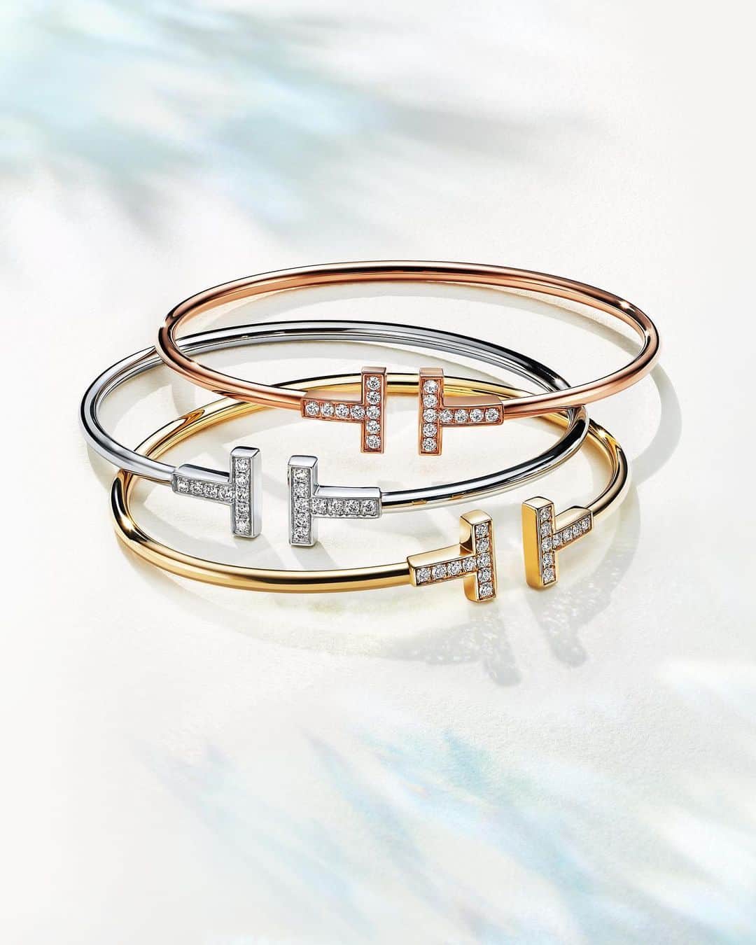 ティファニーのインスタグラム：「This holiday, endless possibilities await. Crafted in 18k white, yellow or rose gold, the Tiffany T collection is an homage to our House name. Punctuated by round brilliant diamonds, these sleek wire bracelets look as striking alone as they do stacked. Link in bio. #ATiffanyHoliday #TiffanyT #TiffanyAndCo」