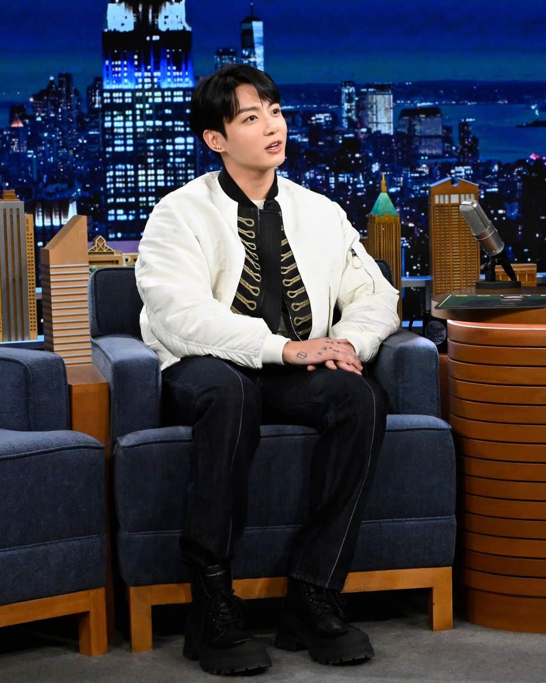 アレキサンダー・マックイーンのインスタグラム：「#JungKook of #BTS wearing a #McQueenSS24 ivory jacket with black and gold ceremonial jacquard, a slashed knit jumper and indigo denim jeans on The Tonight Show starring Jimmy Fallon in New York.⁣ ⁣ #SeenInMcQueen #정국 #FallonTonight」