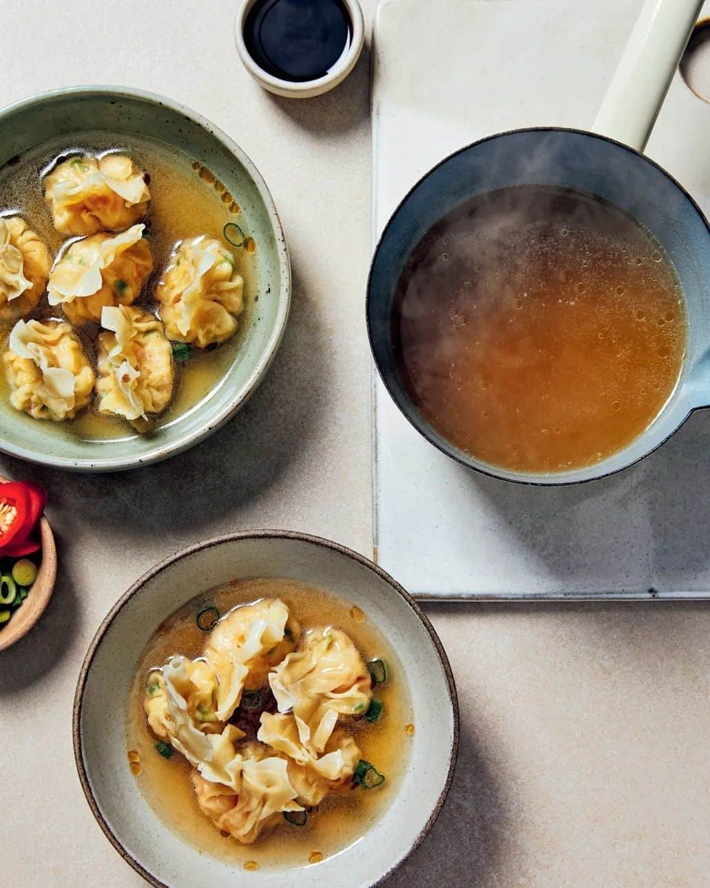 レイチェル・クーのインスタグラム：「WONTONS IN A SMOKY BACON BROTH by @rachelkhooks  On my first trip to visit relatives in Malaysia, I remember an old Chinese man with bike that had been turned into a mobile kitchen. He would ring his bell, a bit like an ice cream van, to let everyone know "The wonton man is here".   People would come outside with empty bowls and return home with them full of steaming soup and savoury dumplings. This was the first time I had ever had noodle soup for breakfast - very different from the cereal, toast and jam I was used to growing up in the UK.  The older I get, the more I crave savoury soups, pickles and fermented foods for breakfast. Despite having lived for eight years in Paris, where the scent of freshly baked croissants wafts onto every neighbourhood rue, I would rather eat a bowl of steaming wonton soup any day.   Wonton soup is a classic Cantonese dish that found its way to Malaysia with the Chinese from Hong Kong and other parts of South China. It's traditionally made with chicken or vegetable stock, but my version uses a smoky bacon broth. The dumplings can be frozen for up to two months in an airtight container. Simply boil them for an additional 5 minutes.  📚 Full Recipe @thesedeliciousthings   📸 Photographer @patricianiven   🎨 Stylist @rosiemackeanpastaqueen   💛 100% Net Profits Donated to @magicbreky   Concept & Curation @janehodsonfood  @lucashollwegfood @clerkenwellboyec1   #TheseDeliciousThings」