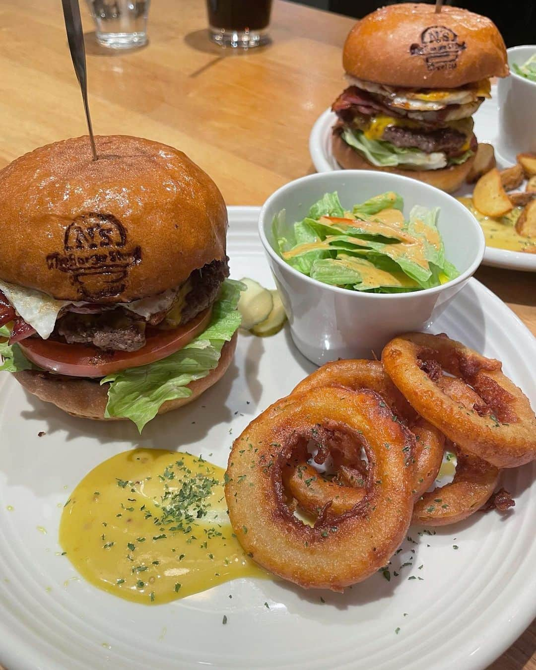 いーちゃんのインスタグラム：「. 名古屋千種のハンバーガー🍔 The Burger Stand -N's-  . お気に入りのお店でもう3~4回？行ってる🫶🏻 本格的なハンバーガーって美味しくて 食べたあとの満足感もすごい🥺🤍 つなぎを一切使用しない牛肉100%の パティがジューシーで旨みたっぷり✌🏻 バンズは程よく焼いてあって香りもいい✨️ 新鮮な野菜もサイドも全部最高に美味しい❣️ . 種類たくさんあって今回はこのバーガー☝️ ︎︎︎︎︎︎☑︎︎︎︎︎︎︎エヌズバーガー･フライドポテト ︎︎︎︎︎︎☑︎︎︎︎︎︎︎ベーコンエッグチーズバーガー･オニオンリング . エヌズバーガーは味の決め手に甘酸っぱさの パイナップルが入ってるのが珍しい🍍 ボリューミーだけど女性も完食できるはず😋 専用のペーパーに移して手で持って食べます✌🏻 . 3階まであって店内広いし内装も おしゃれだから女子会や貸切にも🫶🏻 ランチタイムのセットもおすすめ💛 外のテラス席も気持ちよさそうで 🐶okなのもいいな❤️‍🔥 パーキング🅿️周りに多数あり🚗 . 📍名古屋市千種区池下1-4-20 🏃‍♀️東山線池下駅 徒歩5分 🕐11:00~21:00(不定休) 🐶テラス席OK . . PR @the_burger_stand_ns_ #theburgerstandns #名古屋ハンバーガー #池下ランチ #池下ディナー #池下グルメ #栄グルメ #名古屋ランチ #千種ランチ #千種ディナー #覚王山カフェ #覚王山グルメ #名古屋ディナー  #飯テロ #グルメ好きな人と繋がりたい #グルメ女子 #グルメスタグラム #nagoya #名古屋 #ハンバーガー #ハンバーガー部」