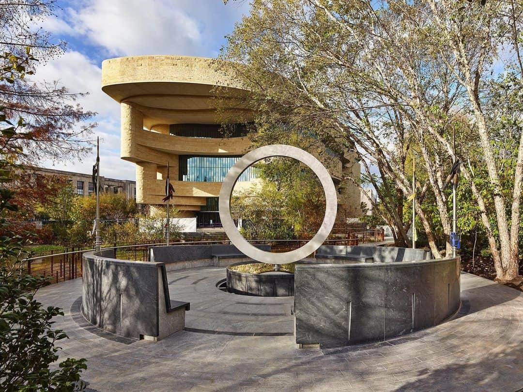 スミソニアン博物館のインスタグラム：「Native Americans have served in the U.S. Armed Forces in extraordinary numbers since the American Revolution. On Veterans Day 2020, our @smithsoniannmai opened the National Native American Veterans Memorial. It is the first national memorial honoring the enduring and distinguished service of Native Americans in every branch of the U.S. military.   The memorial, designed by veteran Harvey Pratt (Cheyenne and Arapaho Tribes of Oklahoma), features an elevated stainless-steel circle balanced on an intricately carved stone drum. It incorporates water for ceremonies, and lances where veterans, family members, tribal leaders and others can tie cloths for prayers and healing.   The memorial was formally dedicated with a procession of more than 1,500 Native Veterans representing more than 120 Native nations and countless supporters on Veterans Day in 2022. Pictured in the procession is a group from the Women Warriors Association.   Photos by Matailong Du and Alan Karchmer for the Smithsonian’s National Museum of the American Indian.」