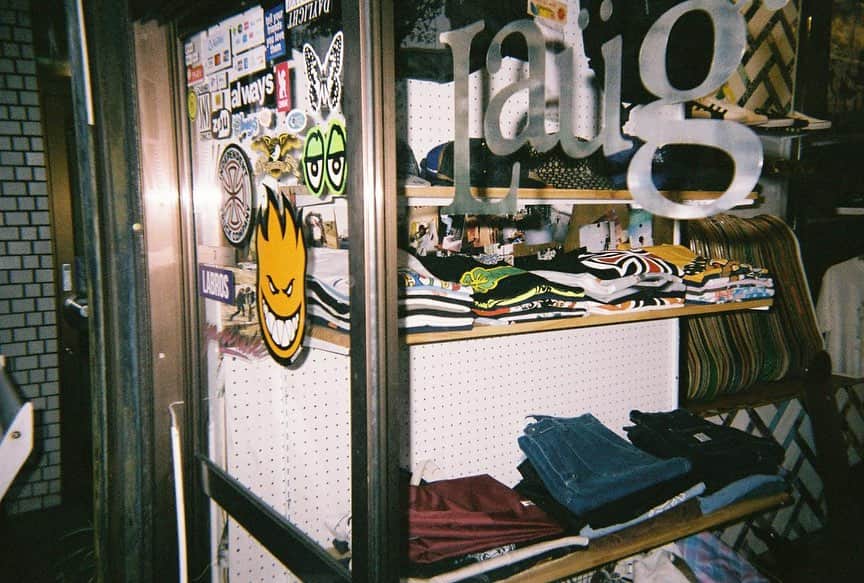 のインスタグラム：「モダンなスケートブランドからクラシックなかんざしまで 日の出町のフリーダムなお店 @_laugstore_   東京の「地元に密着していたり」「まだまだ知られていない」「何やら面白いことをしている」素敵なお店を紹介する本企画。  今回は “Laug Store” 日ノ出町駅から徒歩6分。ハンドメイドの看板と様々なブランドのステッカーが貼られたドアが目印だ。  元々はAtomさんの父がサーフショップを営んでいたところを、20歳の時にスケートボードをしていたという経験を元に、学生ながらAtomさんがスケートボードショップとしてこのお店を引き継いだ。  お店のセレクトはalwaysやsexhippiesなど日本でも中々取り扱いが少ないようなスケーターブランドを始め、親交の深いブランドからLaug storeのスタッフである千㮈さんがオリジナルで作っているかんざしとジャンルレスでユーモラス溢れる商品が並んでいる。  店内は学生時代にAtomさんが仲間達と作ったDIYの作りで、どこか親しみを感じられるような雰囲気だ。  Atomさんは24歳ながら横浜元町にSunburnという古着屋も営んでおり、元々Laugの常連であった仲間と始めたお店で、こちらにもぜひ足を運んで欲しい。  横浜でローカルに活躍するLaug storeに今後も目を離すことができない。  元町のお店 @sunburn_yokohama   Director: @_aymas Producer: @andokeita   McguffinのYoutube“【日ノ出町のスケートボードショップ/Laug Store】モダンなスケートブランドからクラシックなかんざしまで 日ノ出町のフリーダムなお店　GOOD SHOP&HOMIES” をチェック！」