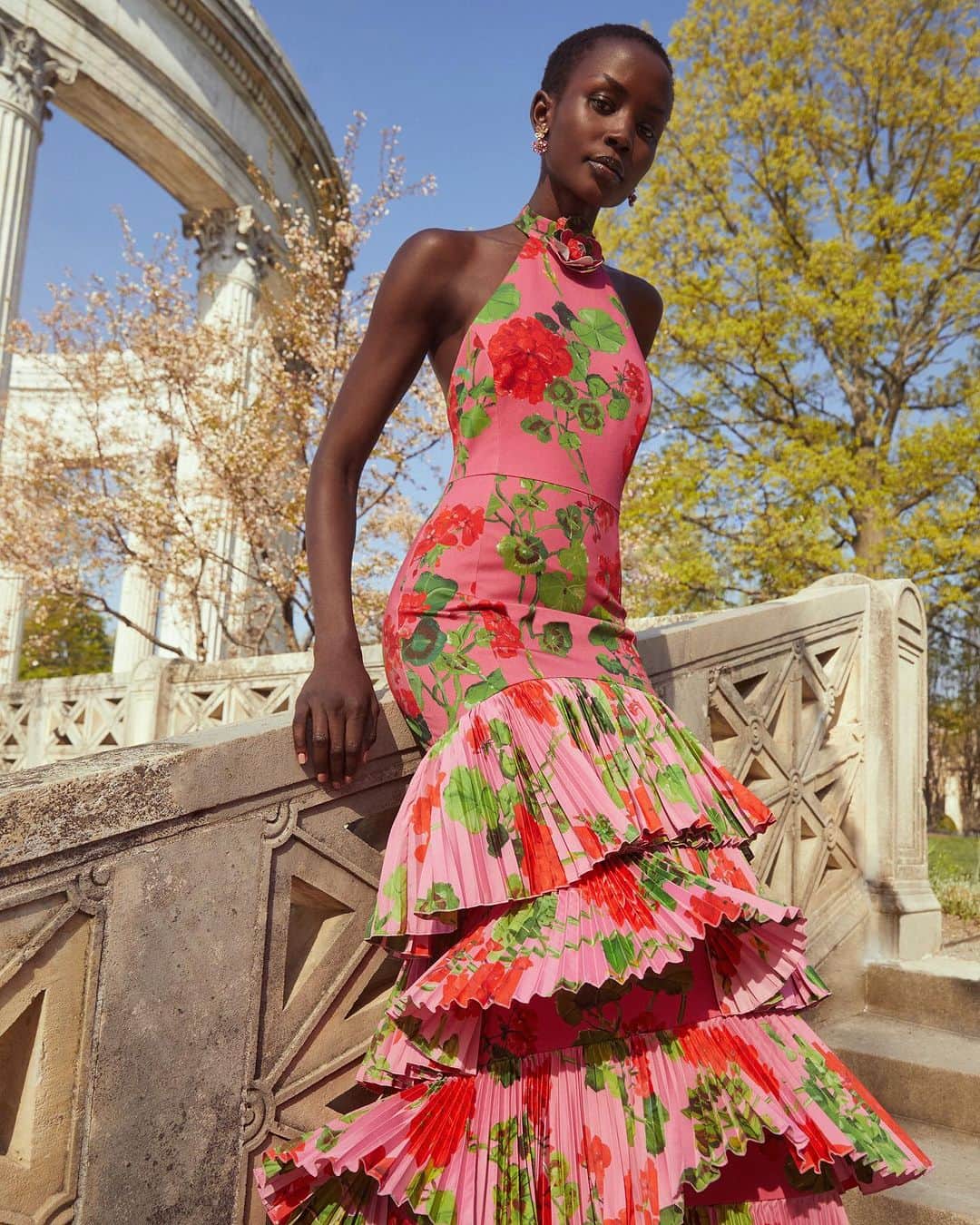 オスカーデラレンタのインスタグラム：「Pretty in pink. Geraniums cascade down the tiered ruffle skirt of the #odlrfall2023 halter gown.  Tap to shop and click the link in bio to discover.」