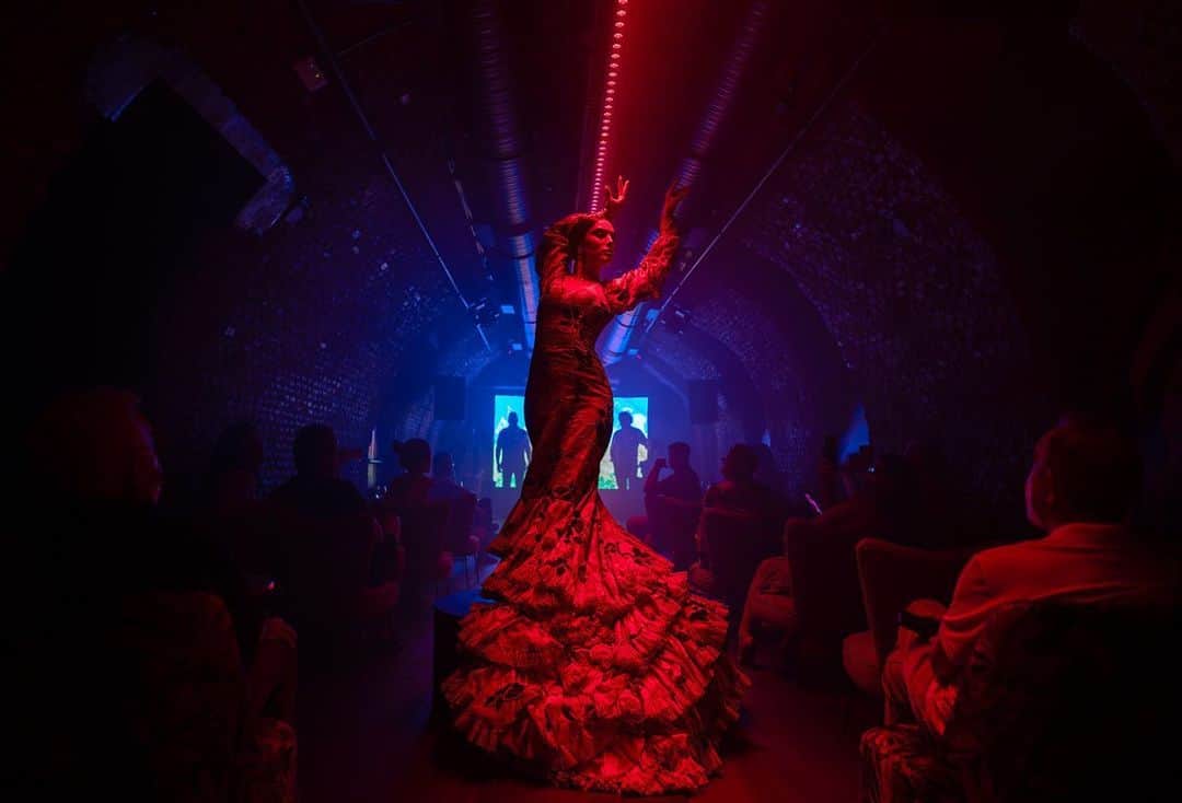 thephotosocietyのインスタグラム：「Photo by @aitorlaraphoto // In the image, we see flamenco dancer Alba Heredia performing during her show at the La Carmela tablao in Madrid. The photograph is part of a National Geographic project that explores the complexity of the flamenco jondo culture. Traditional flamenco is defined as an oral tradition that conveys deep feelings through a primitive, festive, and plaintive style of singing, which narrates and expresses the identity of the Andalusian people in the south of Spain. Flamenco art is a complex, learned, and diverse artistic language. It originated from a mixture of music, dance, and popular poetry elements, resulting from the long coexistence of different cultures such as Arab, Jewish, Christian, and Roma, which blend and fuse throughout the history of Andalusia. In the context of global contemporary culture, it is admired worldwide, constantly expanding because it engages openly with other performing arts, creating contrasts and also new meanings.」