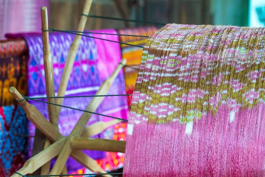 タイ国政府観光庁さんのインスタグラム写真 - (タイ国政府観光庁Instagram)「. ༉‧₊˚ 🇹🇭わざわざ行きタイ旅！ ⠀ ⋯⋯⋯⋯⋯⋯⋯⋯⋯⋯⋯⋯✈  毎週土曜日は、まだあまり知られていないタイの観光スポットをご紹介♪   今回は伝統文化が受け継がれている「バーン・ターサワン・シルク村」へ✨  南イサーンのスリン県にあるバーン・ターサワン・シルク村は、絹織物の伝統と技術を守り続けている場所です🤝  この村で作られる織物は、完全オーダーメイド🪡　織り手はわずか5人ほどで、1日に大体5センチしか織ることができません😌 手元に届くまで数年はかかるという、非常に貴重な特産物なんです💁‍♀️  村を支援するシリキット王太后が特別オーダーされている、最高級品の絹織物産地としても知られながら、織り手の高齢化と後継者不足が深刻な問題に…。そのため村では、この伝統工芸の伝承及び後継者育成に向けた取り組みが行われています✊  ちなみに糸の染色に使われているのは、地元の木の樹皮や葉、冬虫夏草、火山灰土といった天然染料🌿　2003年プーケットで開かれたASEAN首脳会議では、各国代表にこの村のシルクを使ったシャツが贈られているなど、まさにタイが世界に誇る逸品のひとつなんです💝  のどかな雰囲気が魅力的な村では、シルク製品はもちろん、この土地ならではのお土産も手に取れます🛍 タイの伝統文化に触れたい方に、ぜひおすすめしたい旅先です🫶  ☆「行ってみたい！」：いいね❤をタップ ★「参考になった！」：保存ボタン🔖をタップ  #タイ #南イサーン #スリン #バーンターサワンシルク村 #タイシルク #タイ文化 #タイ伝統工芸 #ローカル体験 #秘境 #今こそタイへ #こんなタイ知らなかった #もっと知りタイ #はじめてのタイ #タイ旅行 #スリン旅行 #旅好きな人と繋がりたい #thailand #surin #surintrip #watprathatphasornkaew #banthasawangsilkweavingvillage #thaisilk #thaiculture #thainess #amazingthailand #thailandtravel #thailandtrip #thaistagram #lovethailand #amazingnewchapters」11月11日 17時55分 - amazingthailandjp