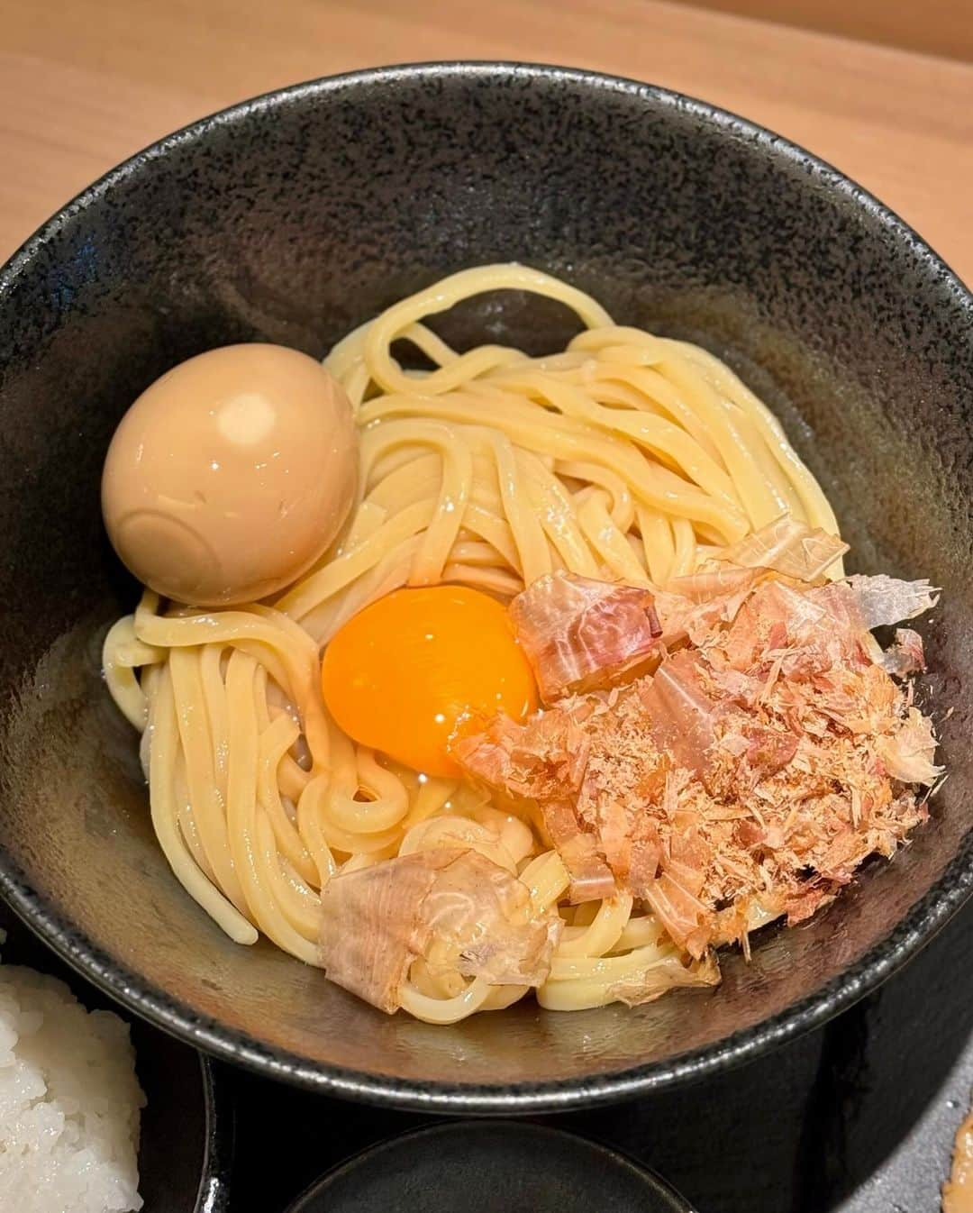 秋山具義のインスタグラム：「神保町『麺屋 二二一』で、「特製たまごかけ麺」中1,300円。 豚2枚・鶏2枚・レモン・わさび・鰹節・小ライス・味玉・玉ねぎ。  よ〜く混ぜて、麺もっちもちでめっちゃ美味しかった！ レモンやわさびや玉ねぎで味変したり、最後にTKGにしたり、楽しい食べ方最高です！  #麺屋ニニ一 #具義ラーメン2023 #具義tkg2023 #具義神保町2023 #具義新店2023 #具義初訪問2023」