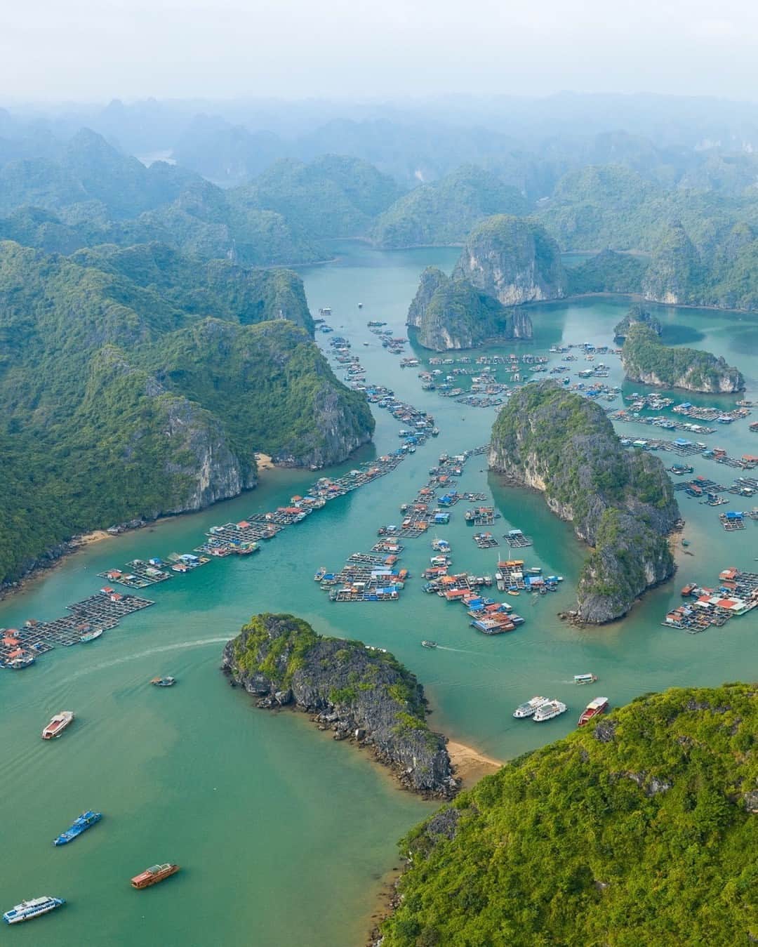 National Geographic Travelのインスタグラム：「Photo by @tobyharriman | This traditional fishing village in Lan Ha Bay, Vietnam, floats atop emerald waters among lush limestone karst formations. Villagers depend on the sea for survival and make a living from fishing, aquaculture, and tourism. It looks like paradise, but their unique way of life is threatened by wastewater and plastic pollution, unsustainable tourist activities, and climate change. Follow @tobyharriman for more. #vietnam #aerial」