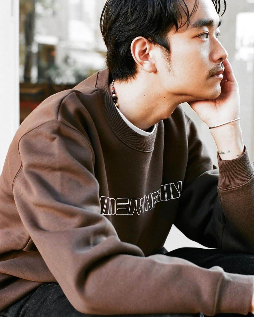 荒井 結生 Yuki Araiさんのインスタグラム写真 - (荒井 結生 Yuki AraiInstagram)「@underthesun_sgj Polygon Logo Sweatshirt   もう発売して1ヶ月くらい経っちゃいましたが…… 新しいUTSのスウェットのデザインをやらせてもらいました。  中川さんに「こういうのがいいなあ」ってレファレンスいただいて、それにならって紙にいろいろ描いてみて、全然わかんないイラレを触って、なんとかできたような……  ブラウンはもちろんかわいいですが、個人的にはアッシュにホワイトのプリントが限りなく無地っぽく、かつ読めそうで読めなさそうな仕上がりで気に入っています。  撮影も新しい空間である @landscape_fukasawa にて、友だちのげんくん @gregor__gg と、写真はこれまた十年来の友だちのMr.Xにお願いしてとっても楽しかったと同時にいろいろな学びがありました。  結果ステッカーにもなって、たくさんの人の手に自分が携わったものが行き渡って、シンプルにうれしいです‼︎  @talisman_org もそうですが、いろんな場所・いろんな形でみなさんにもっともっと自分がやったなにかを供給していけたらと思います‼︎」11月11日 23時31分 - yuki_arai_ayako