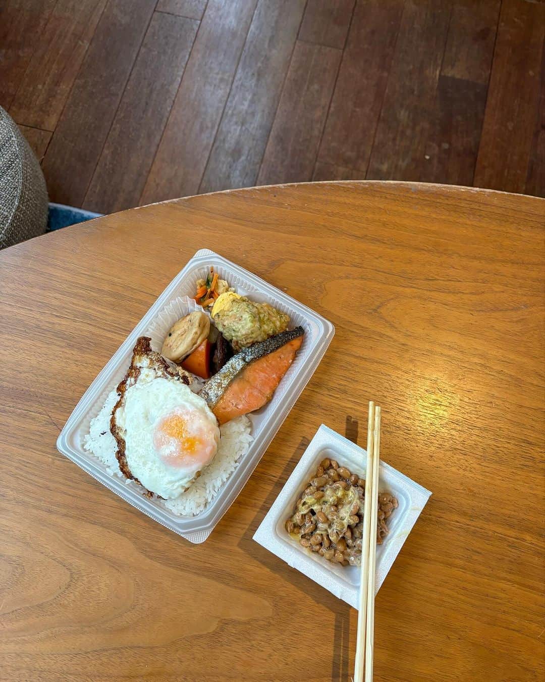 猫沢エミのインスタグラム：「日本滞在・6日目  昨日はネコイチトークショーで大変に忙しく、加えて通常営業の仕事もやらんではおれんな感じで、結果、ごはんを食べる時間がほぼなかった。  数時間の浅い眠りで目が覚めた。あまりにも腹ペコで、着替えて近所のセブンイレブンにお弁当を買いに行く。  ほっともっとの海苔弁が食べたかったけれど、こんな時間（朝7時）には開いてないし、そもそもこのエリアにほっともっとないかな？と探してみたところ、店自体がないのだった。  そうか……ここは高級住宅街エリアなんだわ。たしかにほっともっとの価格帯とは不釣あいかもしれない。  ところで一昔前の私なら、コンビニの弁当（特にごはん）など人間の食べ物ではないと毛嫌いしていたのに、今じゃむしろ「ワァ！こんな早朝にお弁当が買えるだけでもワンダホー♥️」となる。私の外人目線化もあるのだろうけど、コンビニ弁当の向上については目を見張るものがあるよね。本当に美味しくなったよなぁ。  しゃけ弁に納豆付きで、さて食べようと箸をかまえていたら、べっちが起きてきた。コンビニ弁当を食べようとしている私を不憫に思ったのか「目玉焼きくらい焼いてあげるよ。そしたらなんかいい感じになるじゃん？」と、ポンとのせてくれた。  おお✨🍳　いい感じだ。  ごはんの上で、卵の黄身と納豆の情事が始まる。ねっとりと混じり合う食材のエロス……あゝ　運命の白い糸。  べっちが出かけたのち、まったなしの校正作業を3本。新しい仕事もやってきたりして、午前中コツコツ作業していたら、あんこちゃんがじっとこちらを伺っていた。  猫は急には仲良くなれない生き物なのだ。そして対峙する人間が、自分に対して妙に猫扱いしてマウントを取る人なのかどうかを見抜く。  私はこの家でいちばん新参者の下っ端だから、あんこ先輩とはあくまでも静かにアイコンタクトする程度。でも、毎日ちょーっとずつ距離が縮まっている気がする。その〝気がする程度のちょっとずつ〟仲良くなる猫の感じが好きなんだ。  午後。盗難で失った運転免許証の再交付手続きに行きたかったけど、寝不足と疲れがマックスで、背中が完全にブロックされて動けなくなる。  昼風呂に浸かり、観念して午後中寝倒した。そもそも時差ボケをなんとかしようとした私が間違っていたのだ。  時差ボケは1日に1時間しか治らないと言われている。どうせ治った頃にはパリに帰らねばならないのだから、ボケるに任せておけばよかったのだ。こんな生理現象、力技でなんとかできるものではない。眠れる時に寝て無駄なコントロールを試みない、時差ボケ放題にしとけばよかった。  「今からタイムセールで時差ボケ放題‼️」と試しに声に出して言ってみたら、あんこちゃんが「にゃー（バカじゃないの？）」と鳴いた。  #東京下町時間　#時差ボケ放題」