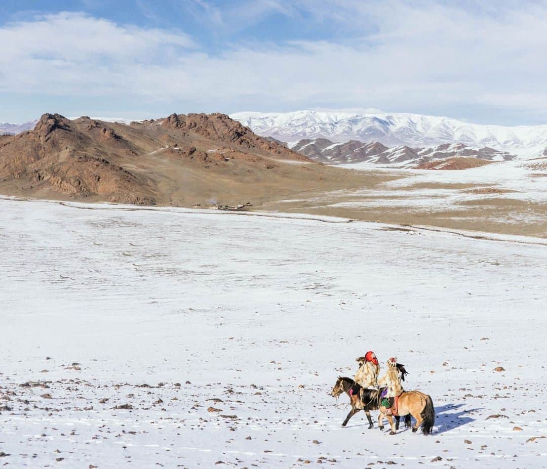 National Geographic Travelのインスタグラム：「Photo by @hannahreyesmorales | Eagle hunters Asker Aigerim (right) and her uncle cross a snow-covered landscape near their home in Altai Soum, Bayan-Ölgiy, Mongolia. Here, the once dwindling art of eagle hunting is passed on to a new generation of Altai Kazakh nomads who are embracing the tradition as part of their identity—and keeping it alive amid modernity.  Follow me @hannahreyesmorales for more stories from Asia and beyond. #Mongolia」