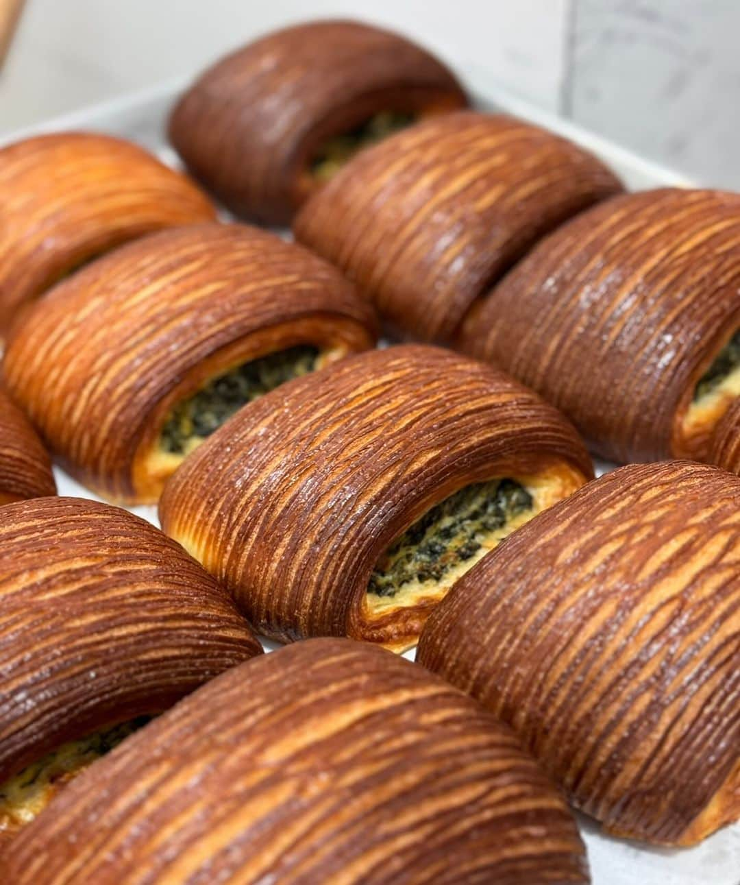 DOMINIQUE ANSEL BAKERYのインスタグラム：「A new addition to our Flatiron Workshop menu: Spinach Ricotta Plié, layers of laminated brioche filled with sautéed spinach and creamy ricotta with a hint of garlic and nutmeg, served warm. Part of our new autumn menu at @dominiqueanselworkshop on 27th street.」