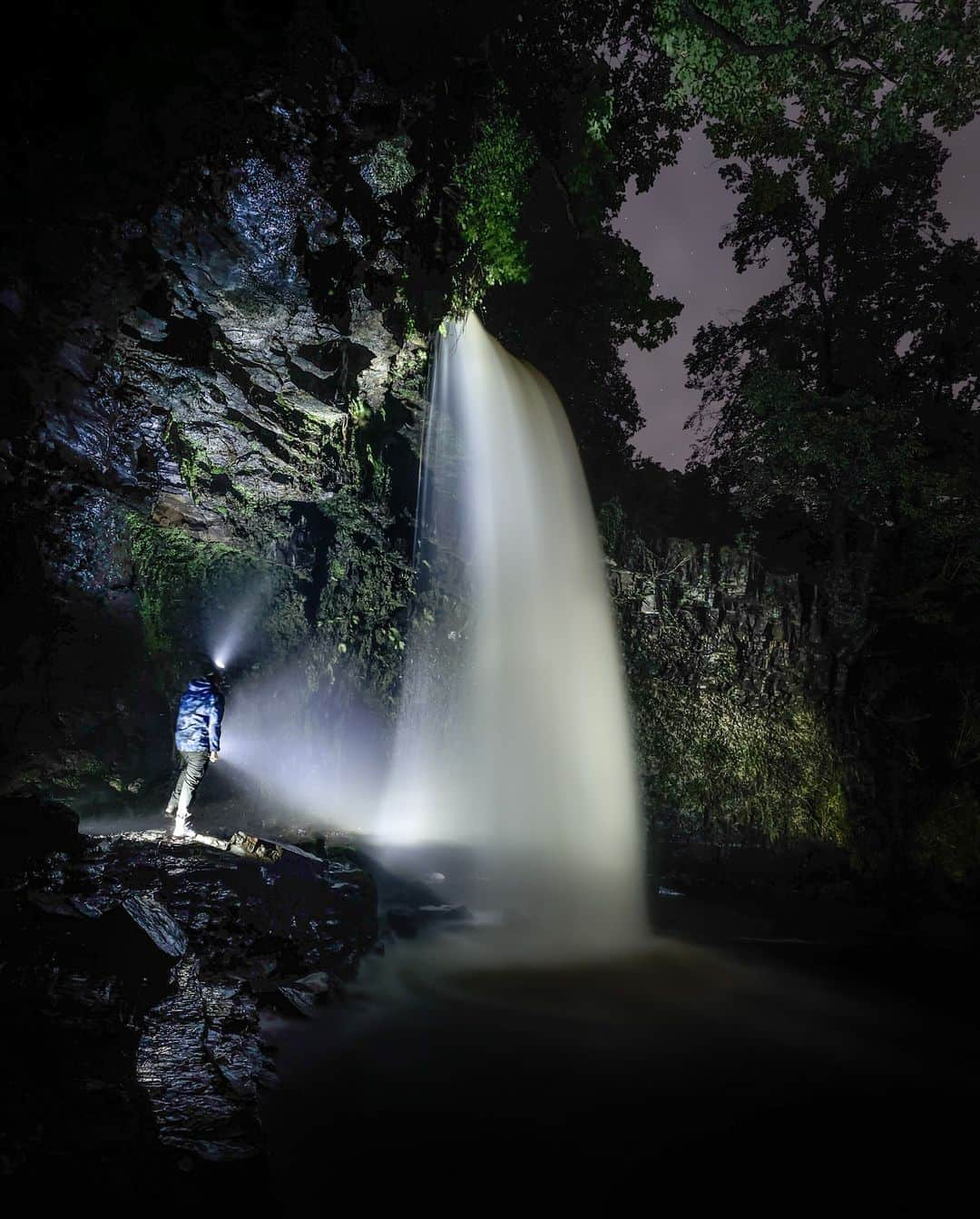 Canon UKさんのインスタグラム写真 - (Canon UKInstagram)「Late night adventures lead to hidden gems 🌊💎 - just don’t forget to pack a torch🔦  @steve.liddiard had always wanted to capture a long exposure shot of this magnificent waterfall at night , with himself in the image to give a sense of scale. To achieve this, he set up a standing light near the falls and a smaller light behind him to illuminate the image.  With a 10- second countdown, he had enough time to walk out and pose for this amazing night shot of the Sgwd Gwladys Waterfall in the Bannau Brycheiniog National Park  Camera: EOS 4000D Lens: EF-S18-55mm f/3.5-5.6 III  Shutter Speed: 1/30, Aperture: f/1.7, ISO 50  #canonuk #mycanon #canon_photography」11月14日 0時52分 - canonuk