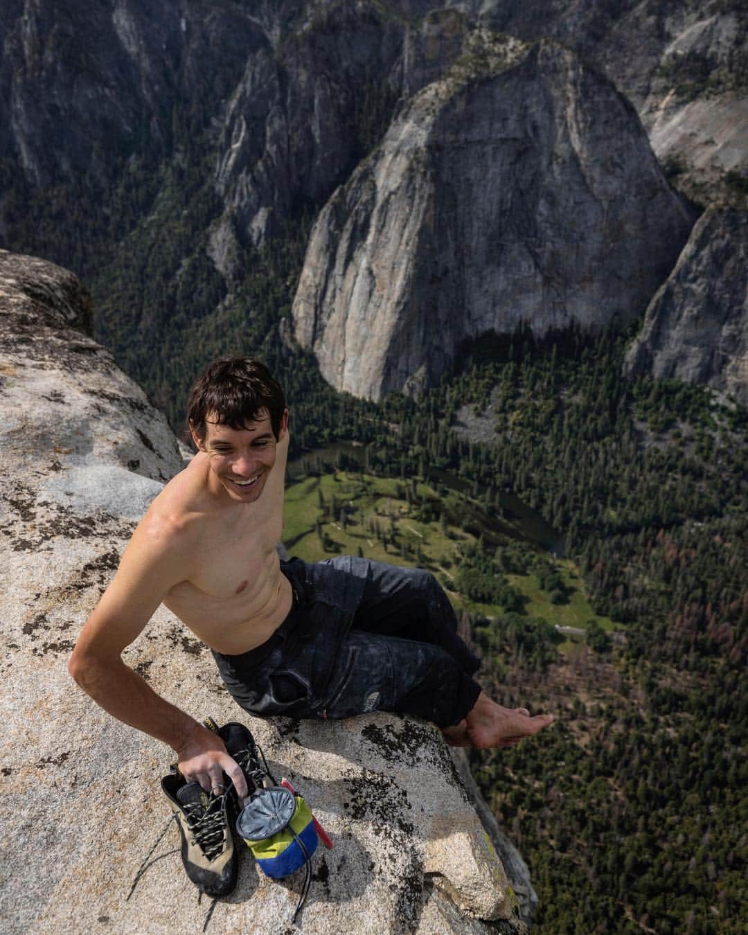 ジミー・チンのインスタグラム：「A moment of bliss.....and relief. @alexhonnold holds his El Cap climbing rack - shoes and chalk bag - moments after topping out after free soloing Freerider.」