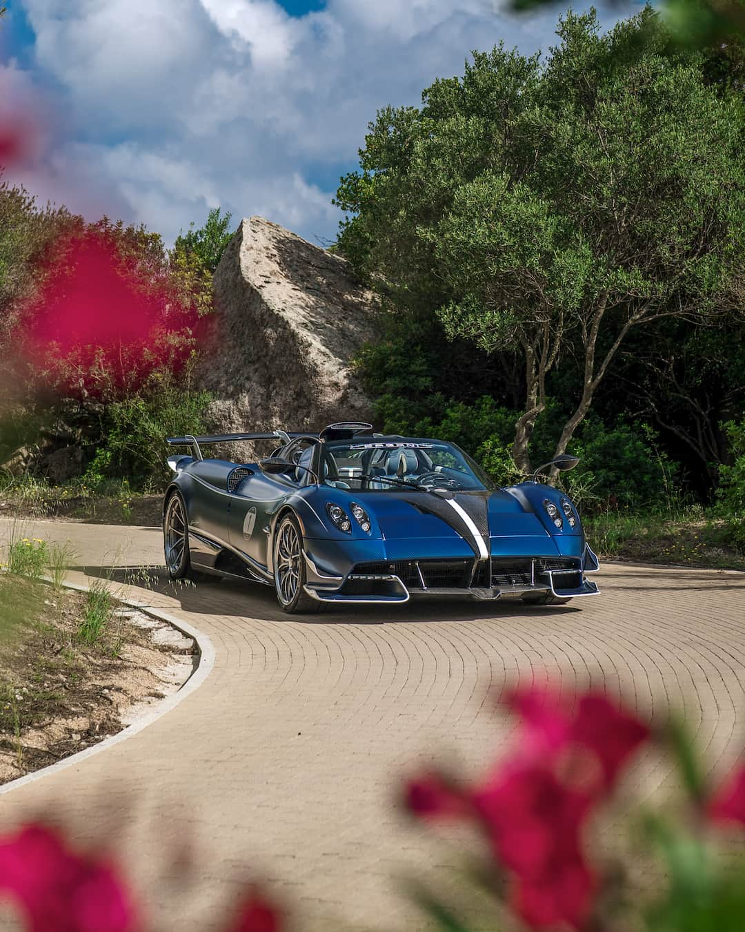 パガーニ・アウトモビリのインスタグラム：「Let us introduce you to a Huayra Roadster that is more than a Huayra Roadster.  The Tempesta Package enhances an iconic Hypercar with added performance, improved efficiency and a more fiercely captivating aesthetic.  No detail has been neglected: a new front splitter designed according to the aerodynamic studies on the Huayra R, a new central air scoop intake, a rear wing, a unique stabilizing “shark fin” and much more.  Some of these improvements are made to be seen, and some of them are just made to be felt while enjoying an open-top driving.  A great way to celebrate the 25th Anniversary of Pagani Automobili.  #Pagani #PaganiAutomobili #HuayraRoadster #TempestaPackage」