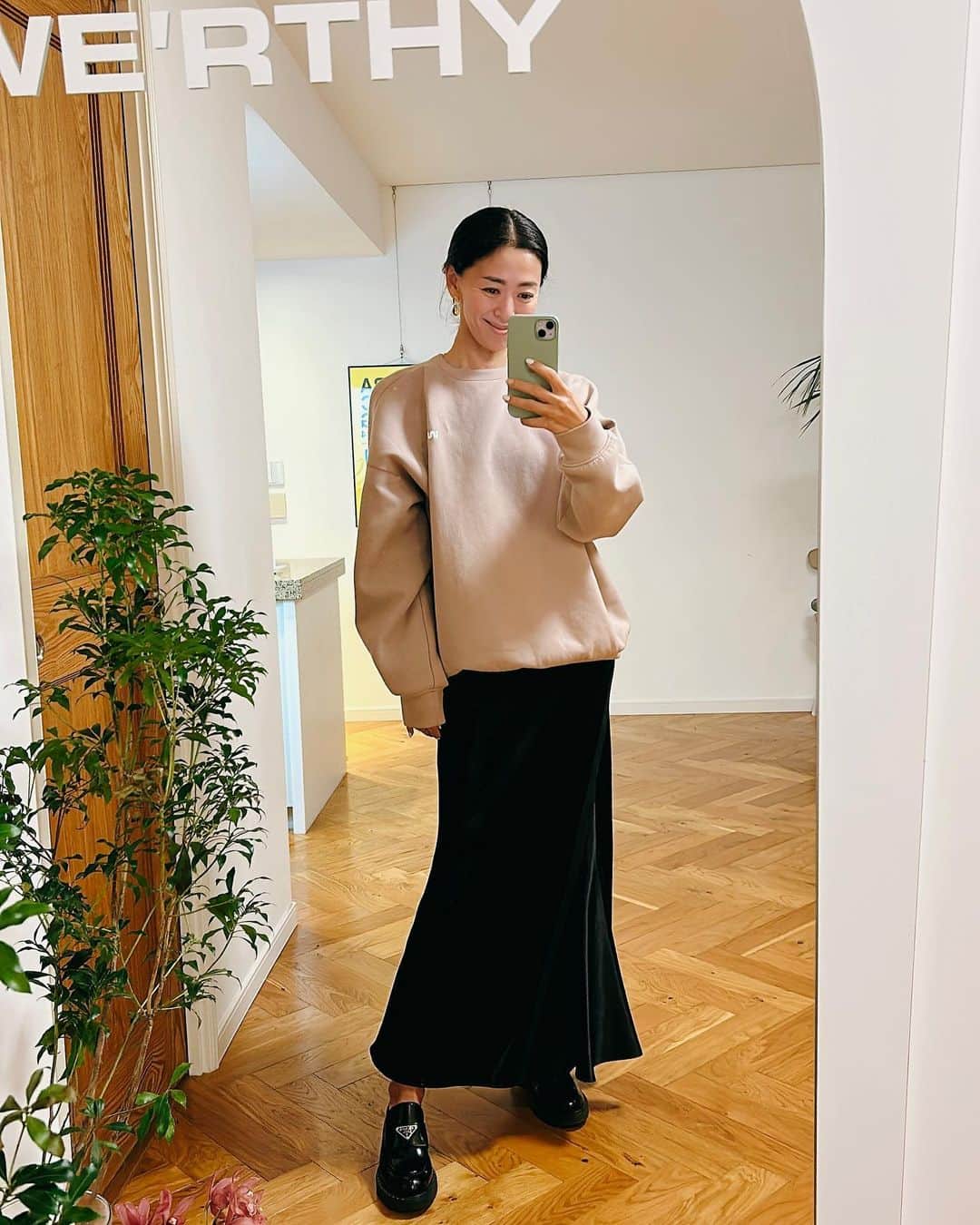 野沢和香のインスタグラム：「木枯らし吹いた今日はWE'RTHY SWEATベージュにサテンスカート🖤 スウェットも女性らしいスカートや、艶のあるサテンやレザーにに合わせるとグッと都会的になる😙  夕方は寒すぎてファーベストを引っ張り出しました🐻 だんだんと冬のオシャレが楽しい季節になりなってきましたね🍂  POP UPで使っていたのは自宅の鏡だったので、WE'RTHYのロゴそのままにしてもらいました🥰しばらくこれを楽しもうと思います♪」
