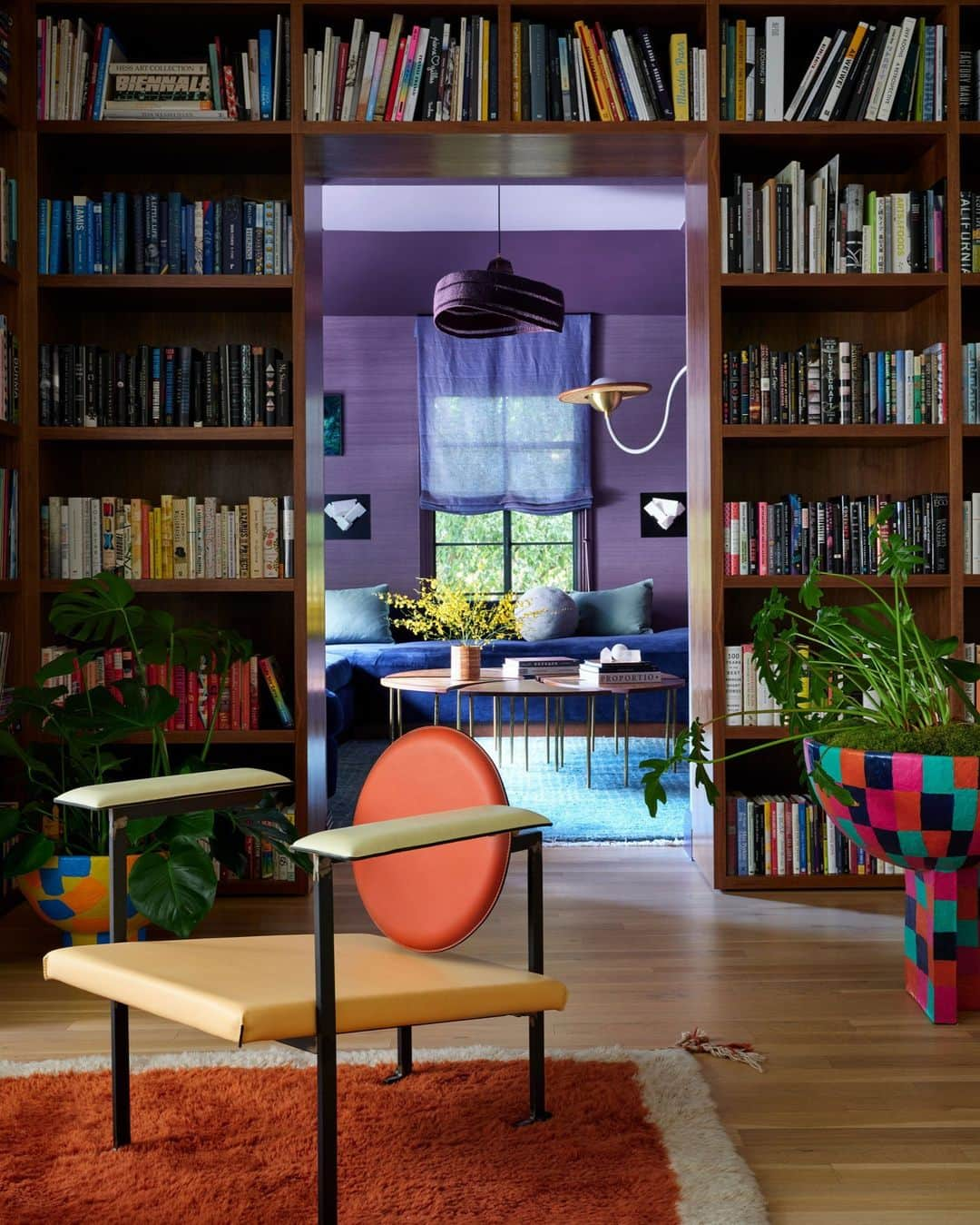 ELLE DECORのインスタグラム：「If there’s one thing Los Angeles–based interior designer Oliver Furth (@olivermfurth) isn’t afraid of, it’s color—and you better believe he’ll take every opportunity to embrace it. So, when Furth’s clients approached him about taking on their new home set among the city’s coveted Bird Streets, just above Sunset Boulevard, the crayon box in his mind spilled right out. Here, for example, a violet living room flows into a media room lined with packed bookshelves and tangerine-hued lounge chairs by @mmariomilana.   To step inside this color-drenched dream home, as toured exclusively on elledecor.com, click the link in bio. Written by @davidbryannash. Photographed by @rogerdaviesphotography.」