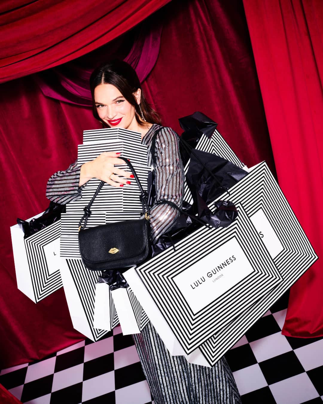 ルルギネスのインスタグラム：「Little Black Bag lovers, rejoice because we've created the perfect LBB! Meet Cara, our new 24-7 Black leather Baguette shoulder bag that effortlessly transforms into a minimalist clutch. As always, it's all in the details with the removable knotted shoulder strap, padded lip stitch detailing, and a solid gold lip plaque. ​  Tap to shop.  #LuluGuinness」