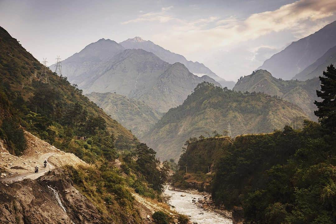 Cory Richardsさんのインスタグラム写真 - (Cory RichardsInstagram)「Our hearts remain with the thousands of families that have lost loved ones in the 6.4 magnitude earthquake in West Nepal. As winter approaches, tens of thousands remain without adequate shelter or warmth. If you’d like to contribute please visit Blinknow.org - these are friends of ours working tirelessly on the ground, and every contribution matters.  We will resume our Mustang travelogue starting today to celebrate all the beauty, resiliency, and magic of Nepal in the faith that if we all work together, brighter days will come soon. // following words by @jetbutterflies Hoping for mountains, we find fog. Climbing towards Sarangkot, the city disappears behind us. Marigolds line the road that falls away into steeped terraces dotted by clusters of roughhewn homes. An hour in, we find the main highway again, paved and twisted into tight curls across the steep hillsides like a pig’s tail. Todd’s back wheel blows up, death-wobbling him across the narrow road and directly into a stable of split-open motor scooters under a corrugated tin roof held together with wire.  The mechanic opens the rear tire, and leaves the parts strewn across the shoulder of the highway. A metal-handled hammer and broken screwdriver finish the job: a blown bearing. The mechanic isn’t much of a talker. He saddles a scooter and buzzes off to somewhere while the town gathers around us, sharing stories and children and a, most proudly, new iPhone 12 ProMax.  They return with two bearings – “Japan” brand. “Best quality”, he says. Four hours of riding to go. @vacheronconstantin @aetherapparel」11月14日 4時18分 - coryrichards