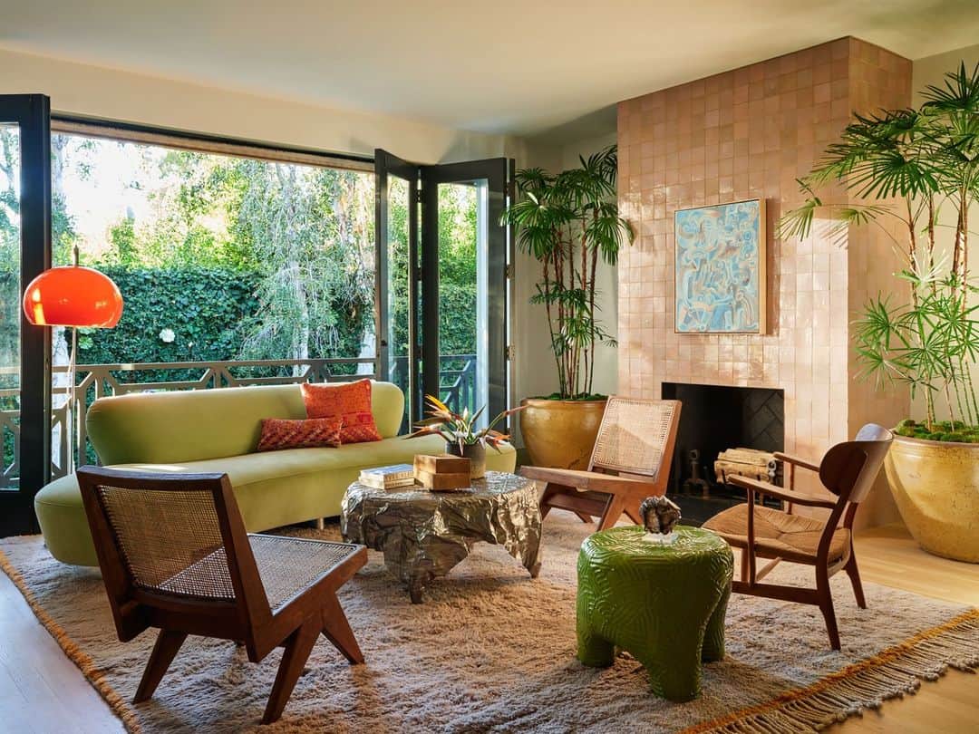ELLE DECORのインスタグラム：「Built in 1948 and surrounded by a wall of tall, lithely swaying bamboo, this “vaguely traditional” three-bedroom, four-bathroom, 4,000-square-foot home immediately gave the ELLE DECOR A-List designer Oliver Furth (@olivermfurth) some serious island vibes. “The house is raised up like those you’d find in the West Indies, and wherever you are inside, the views of bamboo hedges and a swimming pool in the backyard are omnipresent,” he says. “So the idea of warmer climates became a through line in the project.” With views of the yard, this room is a favorite of the homeowners for relaxing with company or simply spending time together. “The warm weather theme is really present in this space with the cane and woven seating, and we clad the fireplace in Moroccan zellige clay tiles from Zia to reflect the light and give the room texture,” adds Furth.  To step inside this color-drenched dream home, as toured exclusively on elledecor.com, click the link in bio. Written by @davidbryannash. Photographed by @rogerdaviesphotography.」