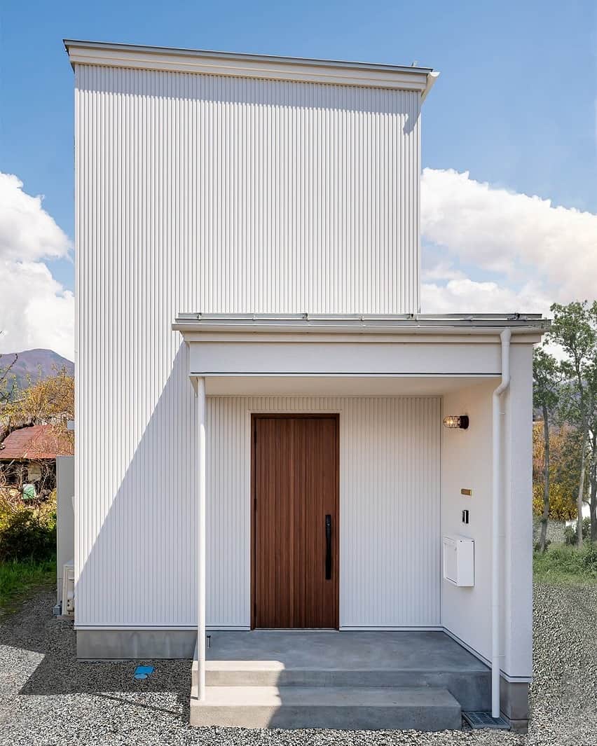 ココチエ建築設計株式会社のインスタグラム：「. 長屋の敷地を活かしたおうち。 白のガルバに木目のドアが目を引きます。 土地の形状に合わせて、日射シュミレーションを行い、日射取得遮蔽をしっかり考えてご提案しております。  - 設計士とつくる高性能デザイン住宅 - ココチエ一級建築士事務所  ココチエstaffによる日常風景と建築現場の様子をご紹介しています。 @cocochie_works からご覧ください！  他にも沢山のおうちをホームページでご紹介しています。 @cocochie_style からご覧ください！ ＿＿＿＿＿＿＿＿＿＿＿＿＿＿＿  ココチエ一級建築士事務所 http://cocochie.com/  contact TEL・0263-87-5648 Mail・info-mail@cocochie.com  Address 長野県安曇野市三郷温4614-1 ＿＿＿＿＿＿＿＿＿＿＿＿＿＿＿ #cocochie  #ココチエ一級建築士事務所 #建築士事務所 #高性能住宅 #エクステリア #新築一戸建て #マイホーム #インテリア #暮らしを楽しむ #ていねいな暮らし #こだわりの家 #家づくり  #パッシブ設計 #デザイン住宅安曇野 #注文住宅松本  #松本市 #安曇野市 #信州 #松本に暮らす #安曇野 #環境にやさしい #白ガルバ #太陽 #日光 #光」