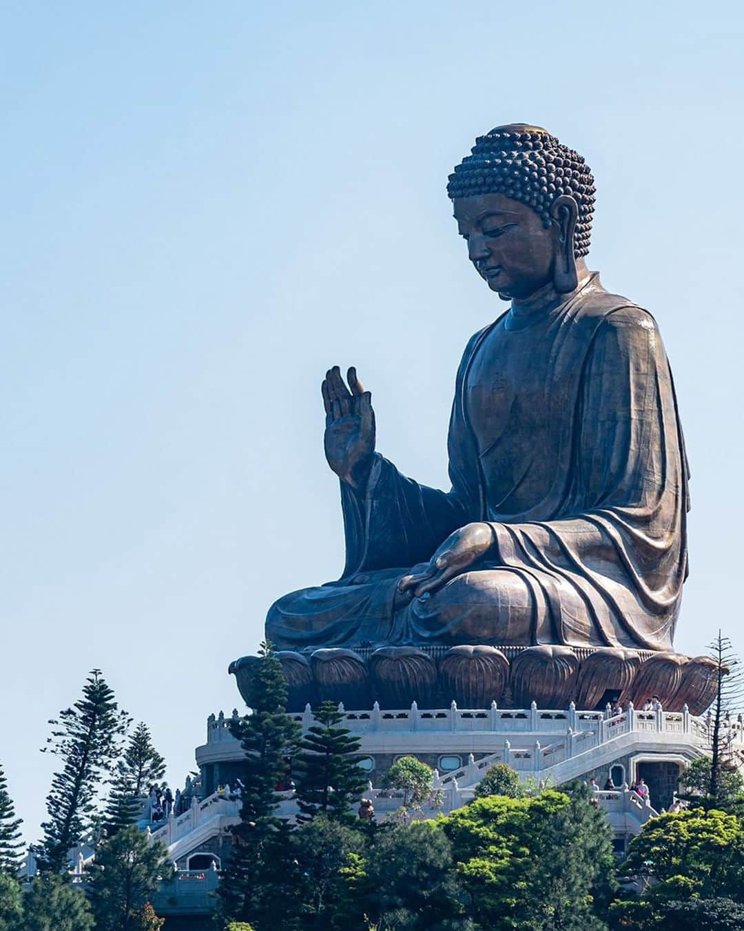 キャセイパシフィック航空のインスタグラム：「The majestic Big Buddha, also known as the Tian Tan Buddha, is one of the largest bronze-made sitting Buddhas in the world. From atop the Lantau Island, the statue overlooks the rolling hills and the glittering South China Sea 🌊.  For the non-hikers, take a bus or ride the Ngong Ping 360 cable car 🚡 to save your fresh legs for the final 268 steps leading up to one of the biggest sitting Buddha statues ever built 👣. And remember to visit the Po Lin Monastery to complete your pilgrimage experience!  #cathaypacific #MoveBeyond  莊嚴宏偉的天壇大佛坐落於大嶼山山頂，為全球最高的青銅坐佛之一。大佛俯瞰連綿起伏的群峰和波光粼粼的南中國海 🌊。  除了遠足外，你可以乘搭巴士或昂坪360纜車 🚡 直達昂坪市集，再登上268級台階參觀天壇大佛。別忘了到鄰近的寶蓮禪寺參拜，圓滿你的旅程！  #國泰航空 #志在飛躍  📸 @takuya_hk, @knchengphotography」