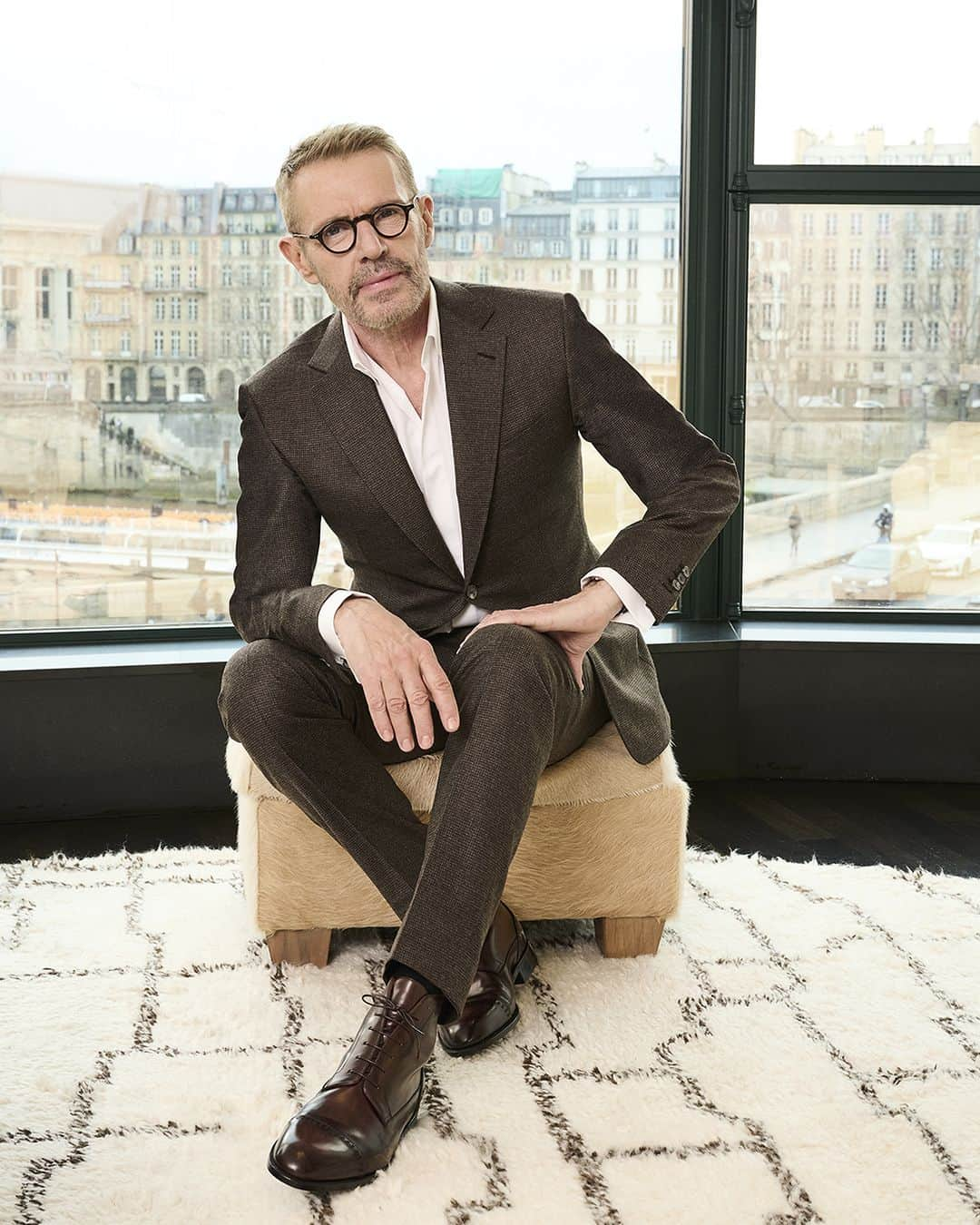 ベルルッティのインスタグラム：「- THE ART OF BESPOKE WITH #BERLUTI: LAMBERT WILSON -   As part of its celebration of creativity and know-how, Berluti supports the Maison’s friends at different key moments in their careers.   It’s time for Lambert Wilson to unveil his bespoke look: a classic yet distinctive two-button suit in a brown houndstooth pattern, complete with a white cotton poplin shirt and a three-button wool drap coat in a matching tone. In keeping with his subtly retro chic theme, the French actor - who is voicing Jon on Disney's Star Wars: Visions airing November 14th - completes his outfit with a pair of boots in ‘Buffaloes’ patinated Venezia leather.   Talent: #LambertWilson Photography: @zoecassavetes  Location: @chevalblancparis   #DRESSEDINBERLUTI」