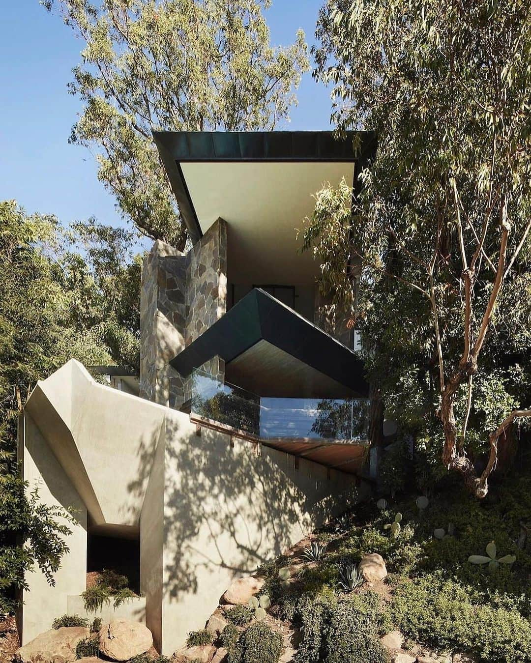 オリバーピープルズのインスタグラム：「The Wolff Residence by #JohnLautner beautifully blends organic architecture and California midcentury design. Designed in 1961, Lautner constructed the home around eucalyptus trees, allowing the space to feel grounded in nature. The organic features contrast with elements of stone, glass, and copper. #OPInspiration⁠ Photo: Sam Frost⁠」