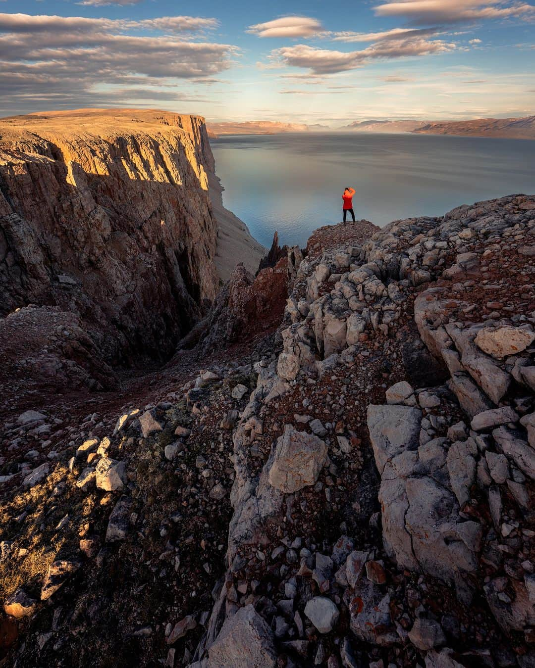 Explore Canadaさんのインスタグラム写真 - (Explore CanadaInstagram)「“For someone who is rarely home, I always search for it when I travel. Home is a feeling. It can be the warm embrace in a quaint village or as fleeting as a conversation in a local store. But perhaps the most special of these moments for me has been in Arctic Bay, Nunavut. Where local guides became good friends, where I serendipitously photographed my first wedding and got to meet with the honorable elder, Qapik in her summer cabin for a chat – reminding me so much of my time with my own grandma.  A heartfelt welcome and friendly hospitality is indicative of being Canadian and can be found across our beautifully diverse landscape – making home feel not so far away, even at the far reaches of the Arctic.” @jdubcaptures  📷: @jdubcaptures  📍 : Nunavut @destinationnunavut  #ExploreCanada #ExploreCanadaCreator #SpiritoftheArctic  Photo description:  Photo 1) Aerial view of buildings, snowmobiles and tents in a vast snowy area. In the background, there are snow capped mountains. Photo 2) Person sitting on a bed looking at their camera. Winter jackets hang above her and a pair of snow boots are at the front of the bed. Photo 3) Iceberg floating in a body of water. In the distance, there’s a boat and mountains. Clouds are in the sky. Photo 4) Wide shot of a mountain, in the distance there is a body of water and a person facing it. Photo 5) Red rocky mountain with a waterfall running through it. Photo 6) Person sitting on a bed holding the hand of a child, whose back is towards the camera. Beside the bed is a nightstand with a clock, eye glasses and a bottle of water.」11月15日 2時30分 - explorecanada