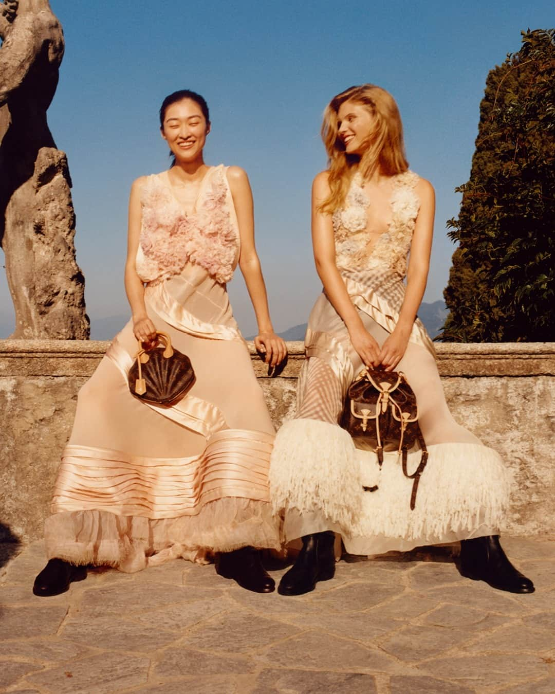 ルイ・ヴィトンのインスタグラム：「Women’s Cruise 2024. Lustrous silhouettes from @NicolasGhesquiere’s latest collection bathe in the evening light, dazzling with their iridescence and dream-like quality, against the backdrop of the breathtaking Lake Maggiore. Explore the creations via link in bio.  #NicolasGhesquiere #LVCRUISE24 #LouisVuitton」