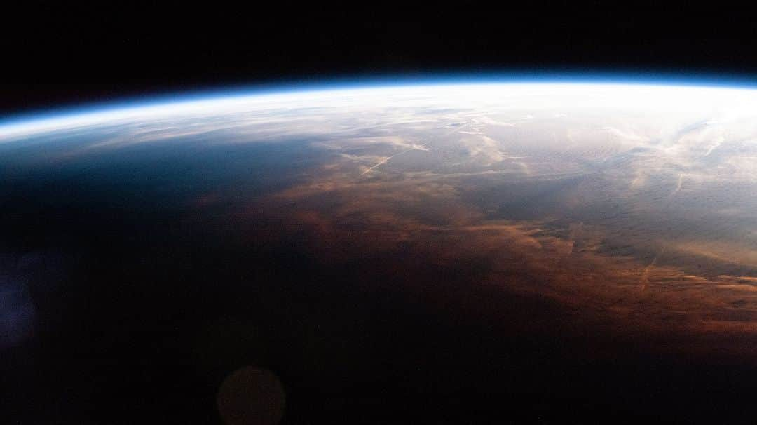 国際宇宙ステーションのインスタグラム：「As the International Space Station entered orbital nighttime 260 miles above the Southernmost Point of Alaska, shadows can be seen reaching a wall of clouds colored coral from the Sun.  #nasa #earth #alaska #night #clouds #sun #international #space #station」