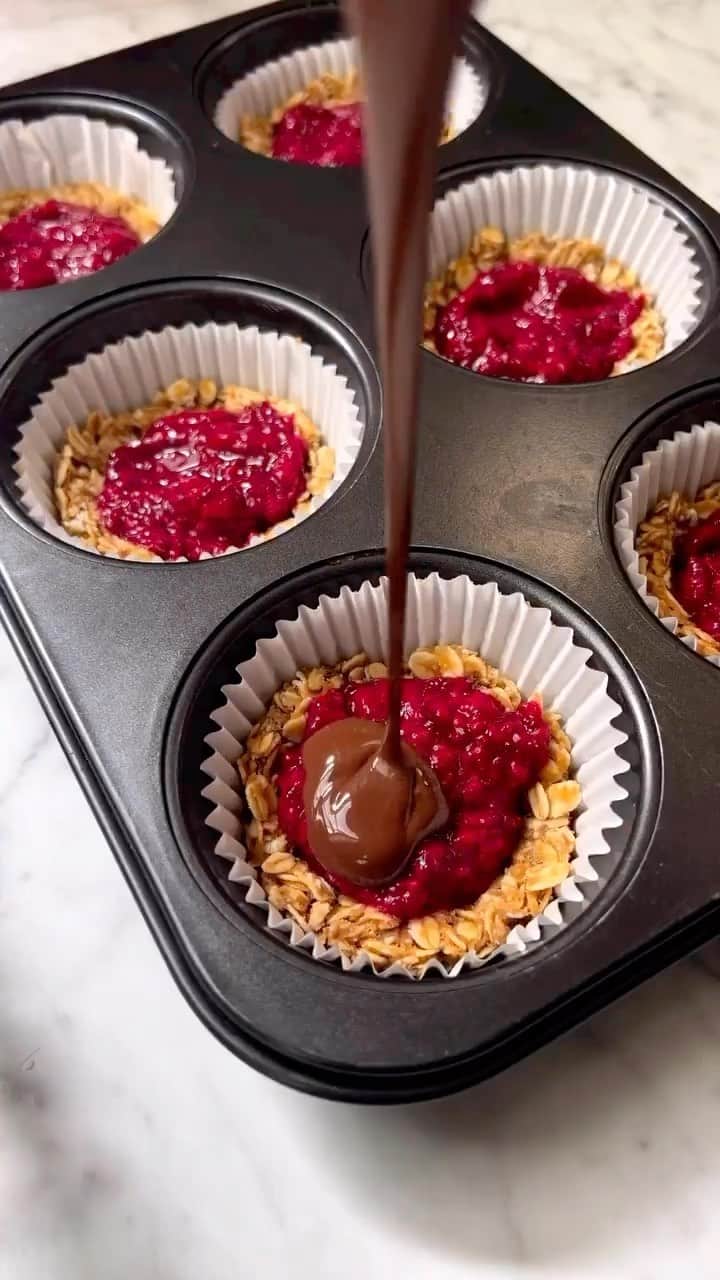 Sharing Healthy Snack Ideasのインスタグラム：「NO BAKE OATMEAL RASPBERRY CUPS by • @cook.vegetarian  Throwback to this easy and healthy sweet treat. No bake desserts are my absolute favourites. Whether I’m craving a quick snack or planning a special occasion, these treats always hit the spot.  Ingredients: 1 banana 1/2 cup peanut butter or any nut butter 1 cup rolled oats 1 1/2 cup fresh or frozen raspberries (if frozen thaw them) 2 tablespoons chia seeds 1 tablespoon maple syrup 150g dark chocolate 1 tablespoon melted coconut oil Method: Line a muffin tin with the liners. In a bowl mash banana. Add in peanut butter and oats. Mix everything to combine. Scoop tablespoons of the mixture and form into a ball. Place the mixture into the liner and press down firmly and make a dent in the center of each cup. Add raspberries, chia seeds and maple into a blender. Pulse a few seconds until smooth. Add tablespoon of the raspberry mixture to each cup. Melt chocolate and coconut oil together. Pour melted chocolate over each cup, spread over the raspberry mixture in an even layer. Place in fridge for 1 hour to harden or in a freezer for 15 minutes. Enjoy!  #oatmeal #vegan #veganfoodshare #nobake #nobakedessert #glutenfree  #plantbased #plantbaseddiet #plantbasedrecipes #healthyrecipes #healthyfood #healthylifestyle #healthychoices #healthyeating #foodreels #recipeshare」