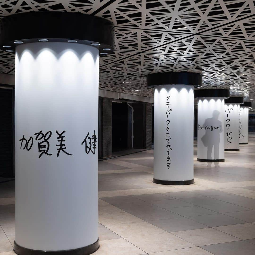 GINZA SONY PARK PROJECTのインスタグラム：「【銀座駅地下コンコースに並ぶ「加賀美健」/ "KEN KAGAMI world" lined up in the underground concourse of Ginza Station 】  自分の名前がフルネームで刻まれている様子にご本人もびっくりされていた地下コンコースの柱。 開催中の『パークローゼット』で展開する加賀美健さんの「ダメージショップ ダメダメ!!」から漏れ出すその世界観を1本ずつたどりながら、Sony Park Miniへお越しください。  KEN KAGAMI's Damage Shop Dame Dame!!, which is being developed in the "ParCloset" exhibition.  Visit our Sony Park Mini and trace the worldview that leaks out from the Damage Shop Dame Dame!!  @kenkagami #加賀美健 #パークローゼット #ParCloset #ダメージショップダメダメ #銀座ギャラリー #銀座アート巡り #SonyParkMini #SonyPark #Ginza #GinzaSonyParkProject」