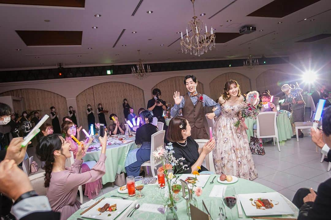 結婚式場 ヒルズスィーツ宇都宮ブリーズテラスさんのインスタグラム写真 - (結婚式場 ヒルズスィーツ宇都宮ブリーズテラスInstagram)「まるでアイドルのライブ会場♡  ゲストの推しは…新郎新婦♡♡  カラフルに輝くペンライトに 推しうちわがキラキラと入場をさらに華やかに！  ゲストからの愛をたくさん受けて幸せですね♡  ゲストにとって新郎新婦って アイドルですよね＾＾ 笑ってくれたら嬉しくて 手を振ってくれたらわー！っと振り返したくて とにかく写真に残したくて 話せたらなんか涙が出てきちゃう  大好きが溢れる空間は愛がいっぱい ____  新郎新婦のリアルなお声や こだわりポイントなどを 公式HPに掲載しております  ヒルズスィーツのTOPページより ぜひご覧くださいませ♡ @hillssweets_wedding  ___  #プレ花嫁 #結婚式 #日本中のプレ花嫁さんと繋がりたい #ウエディング #結婚式場 #全国のプレ花嫁さんと繋がりたい #結婚式場 #wedding #フィオーレビアンカ #fiorebianca #宇都宮結婚式場 #栃木結婚式場 #ヒルズスィーツ宇都宮ブリーズテラス #ヒルズ #お色直し入場 #アイドル #ペンライト #推しは新郎新婦」11月17日 19時45分 - hillssweets_wedding