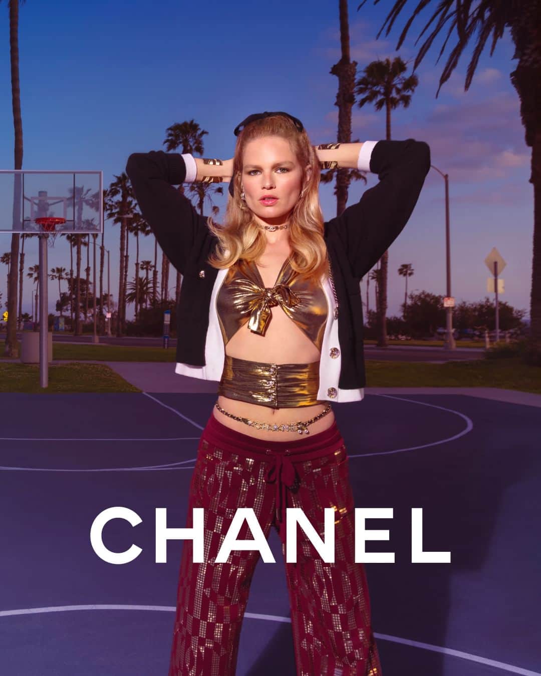 シャネルのインスタグラム：「Subverting the codes — for the CHANEL Cruise 2023/24 collection, Anna Ewers sports an emblematic CHANEL cashmere cardigan worn over a knotted bustier in liquid golden lamé, as a nod to a revisited disco era.  Photographed by Inez & Vinoodh.  The collection is now available in boutiques.  See more at chanel.com  #CHANELCruise @InezandVinoodh @AnnaEwers」