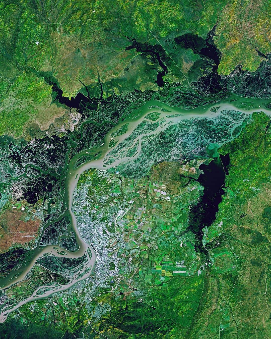 Daily Overviewのインスタグラム：「The Amur River passes through the city of Khabarovsk, spreading out into a dramatic braided pattern on its path through eastern Russia. As the world’s tenth-longest river, the Amur flows 1,755 miles (2,824 km) to form much of the border between the Russian Far East and Northeastern China. The first permanent bridge across the Amur was built in Khabarovsk in 1916, allowing the Trans-Siberian Railway to cross the 1.6-mile (2.6 km) span more efficiently.  Created by @dailyoverview Source imagery: @planetlabs」